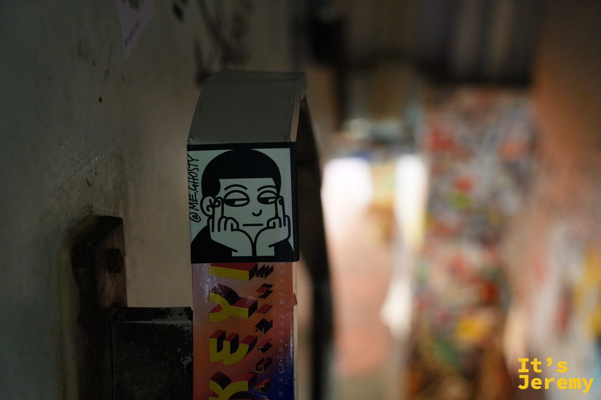 @me_ghosty 的卡通人物貼紙:托著腮的黑白插圖人物,背景是模糊的貼紙牆