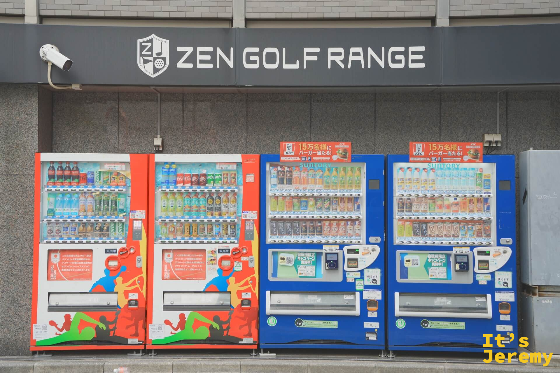 上野站附近路邊，四台色彩繽紛的自動販賣機並排站在 ZEN GOLF RANGE 招牌下，紅藍交錯的機身在灰色街道上特別顯眼