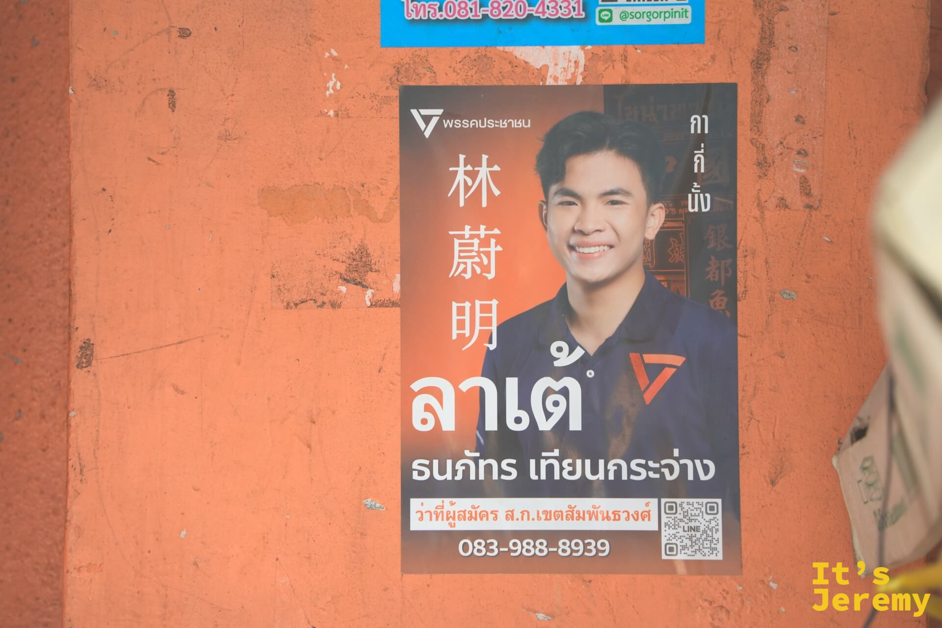 橘色牆面的選區立委候選人競選海報,漢字「林蔚明」與泰文「ลาเต้」雙語並列,嵩越路的多文化日常縮影