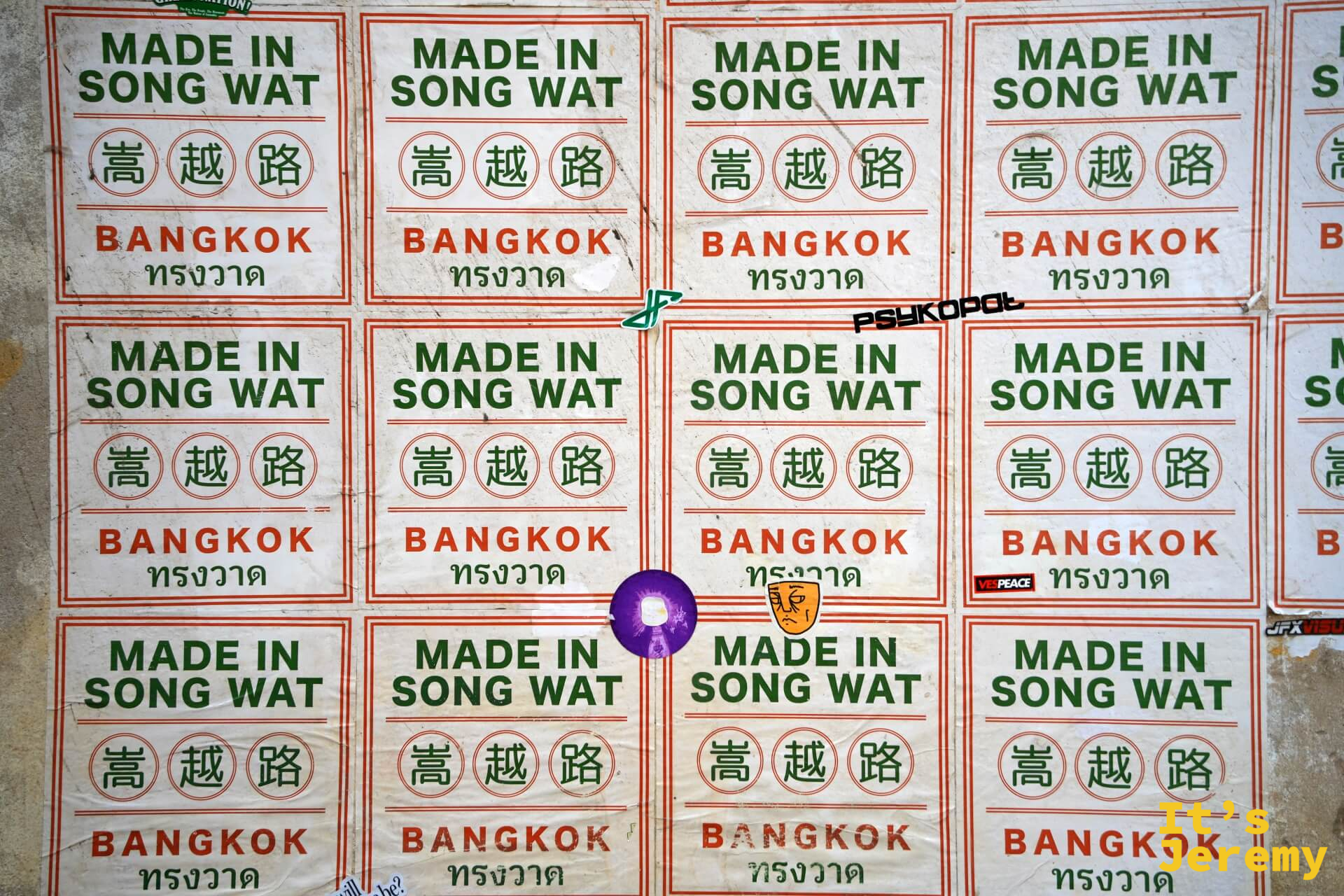 整面牆鋪滿「MADE IN SONG WAT 嵩越路 BANGKOK ทรงวาด」方形貼紙,整齊排列如海關標章