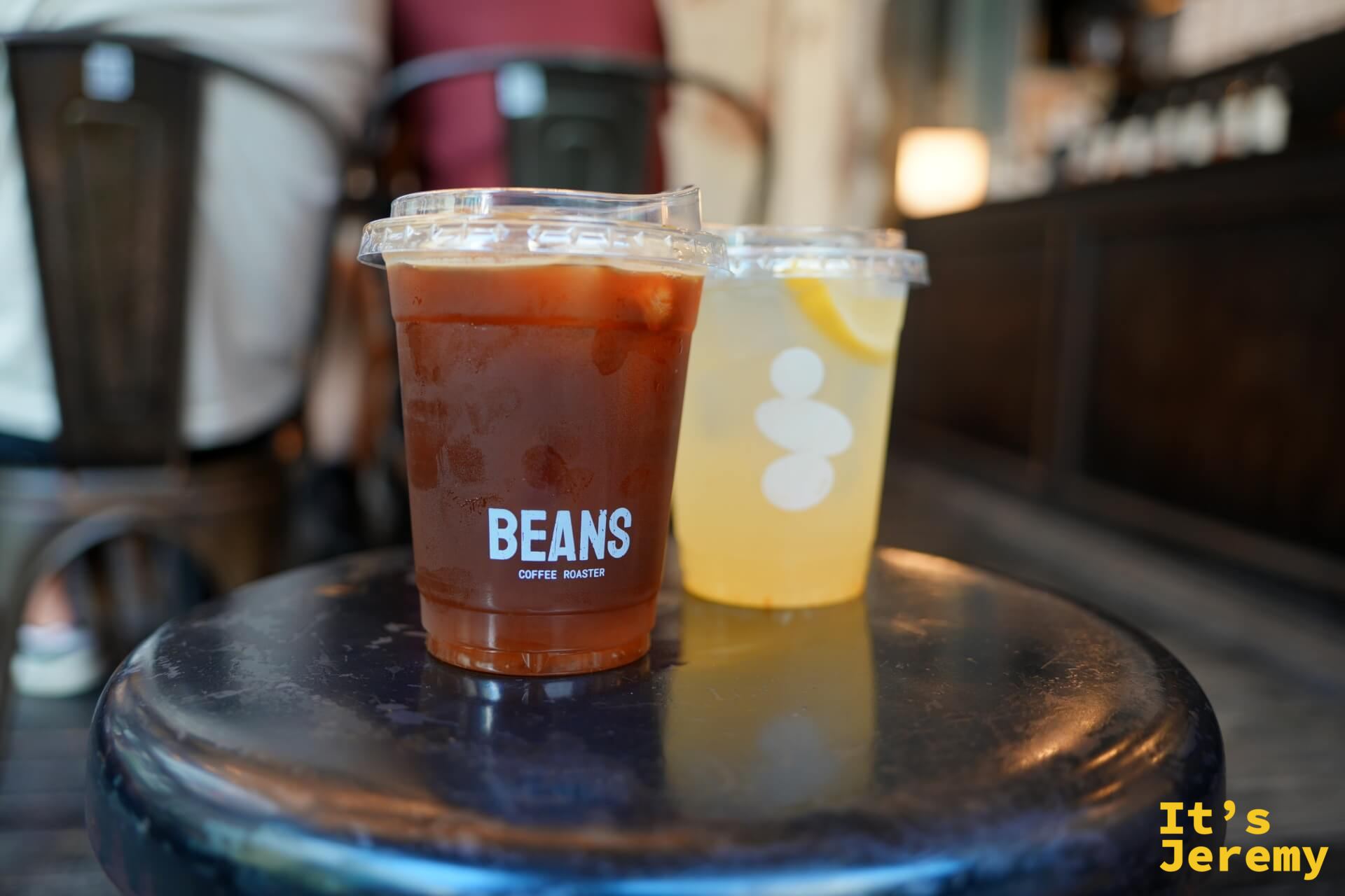 桌上兩杯:左為深棕色 Songwat Blend,右為淡黃色 Yuzu Soda,可見柚子切片沉於杯底