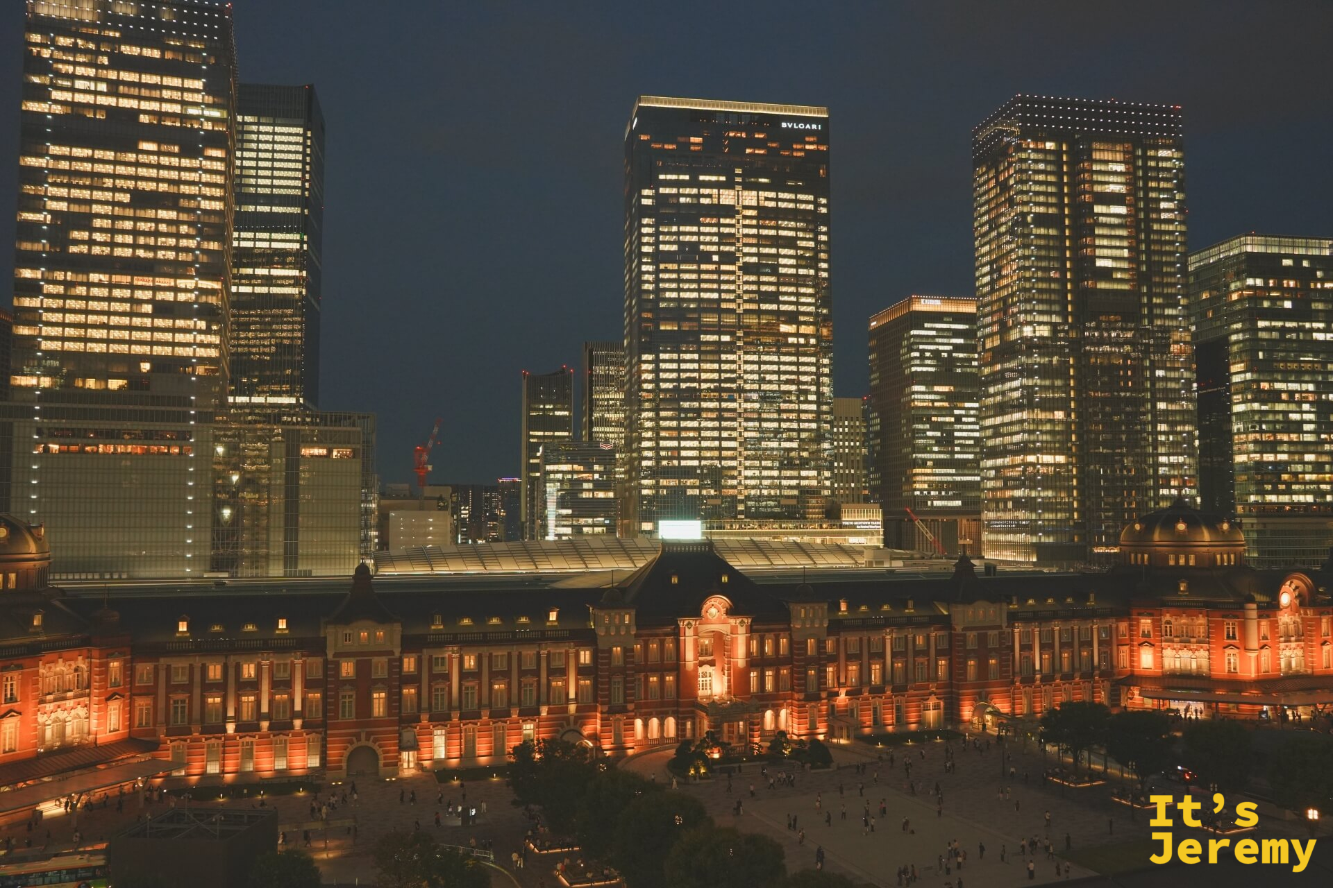 深夜全幅橫景,東京車站橘光點燈,丸之內摩天大樓群各自散發藍白色辦公室燈光