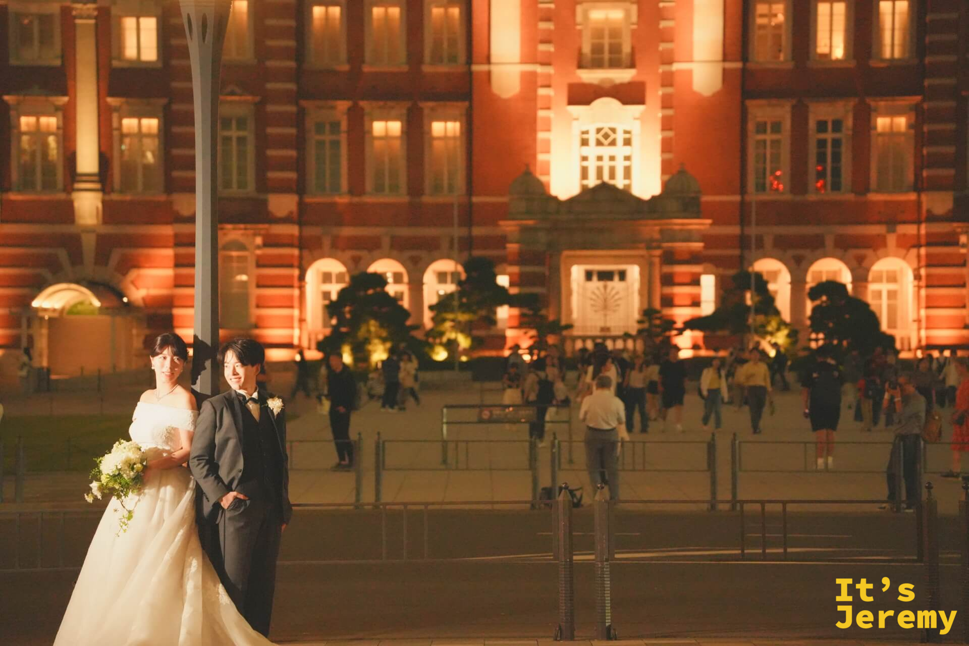 廣場燈柱旁,一對新人在東京車站橘紅燈光前拍攝婚紗照