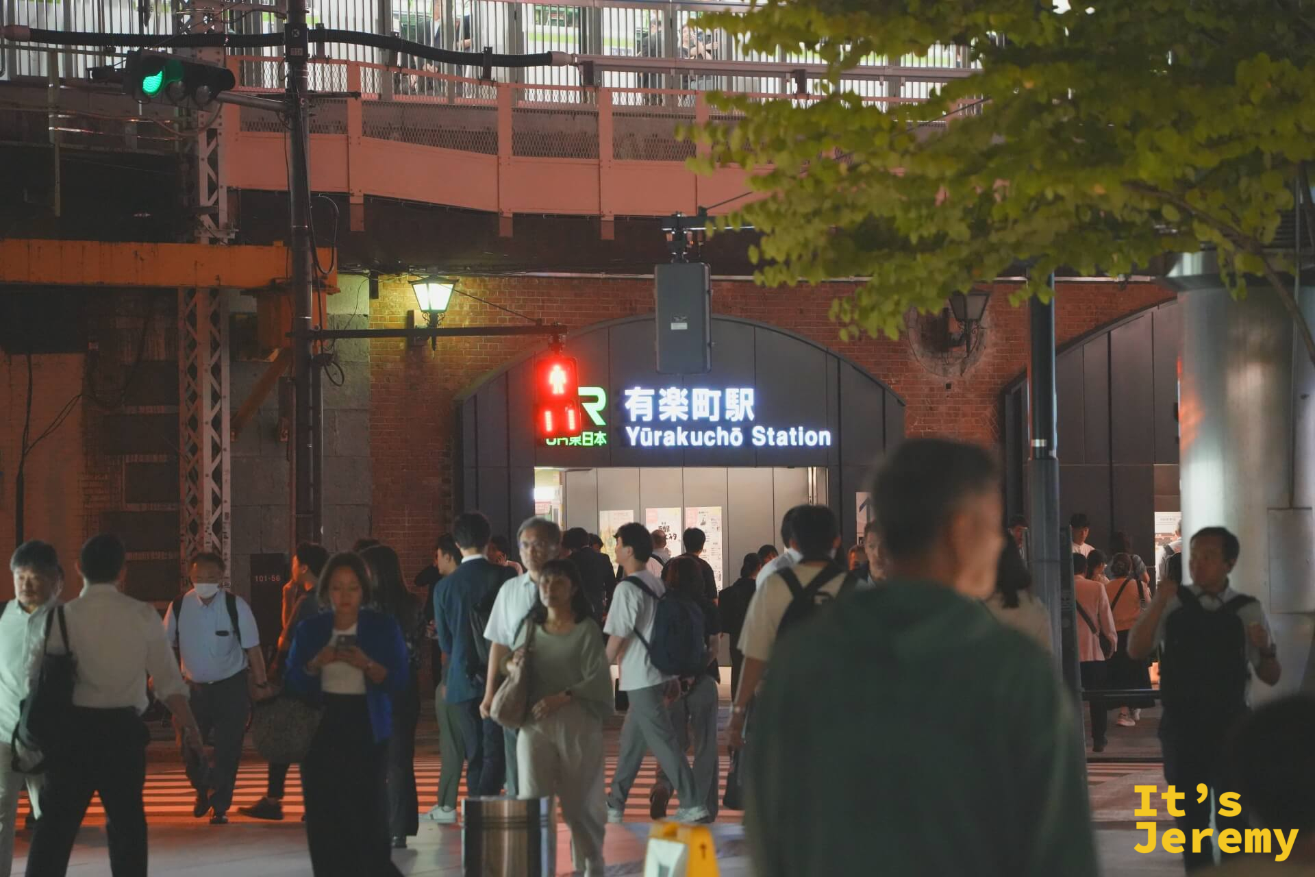 入夜的東京國際論壇廣場附近，JR 有楽町駅的紅磚高架橋底下，人群在站前聚集等待