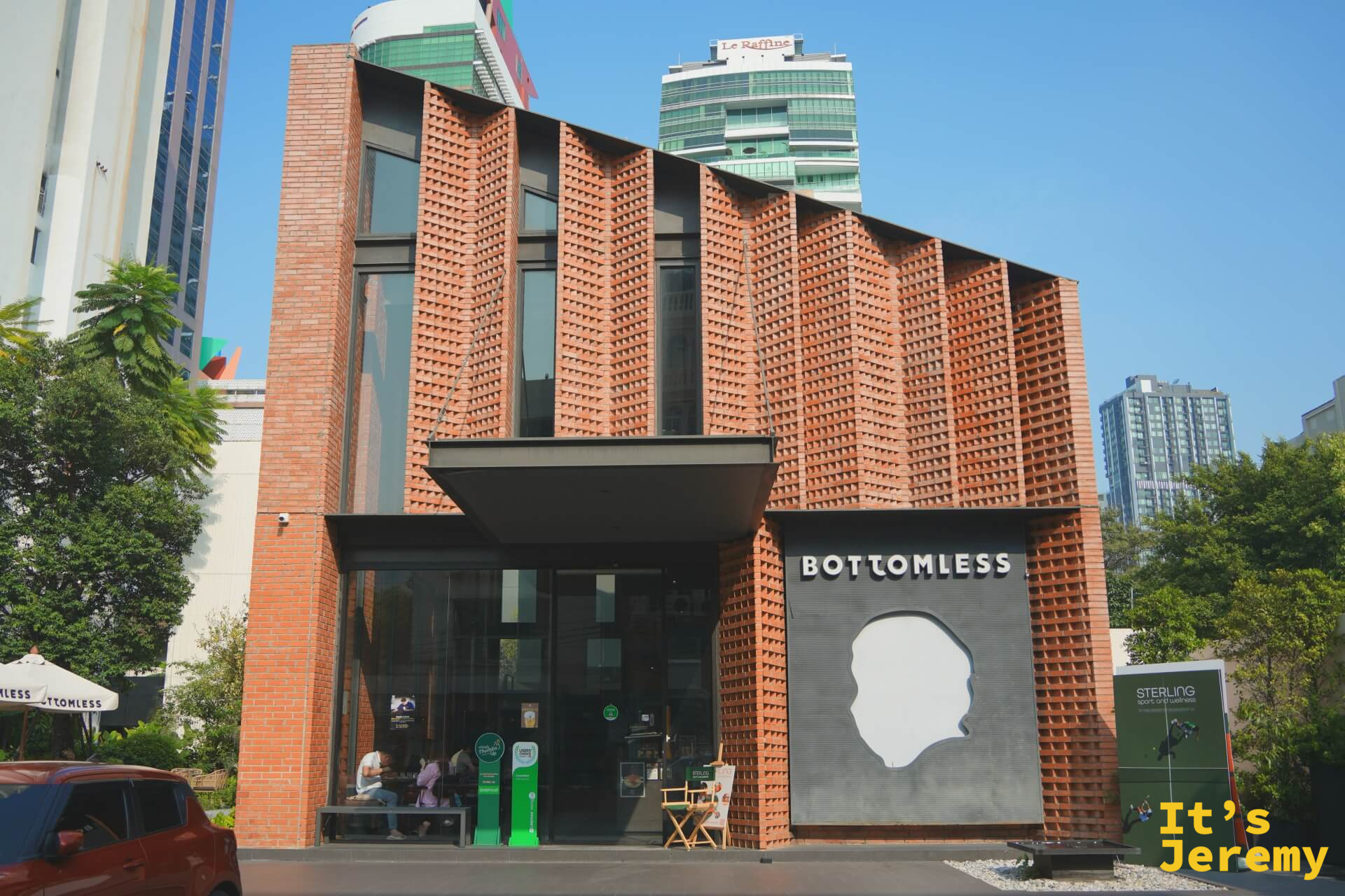 BOTTOMLESS 入口正面全景，左側大門，右側大型人頭 logo 牆