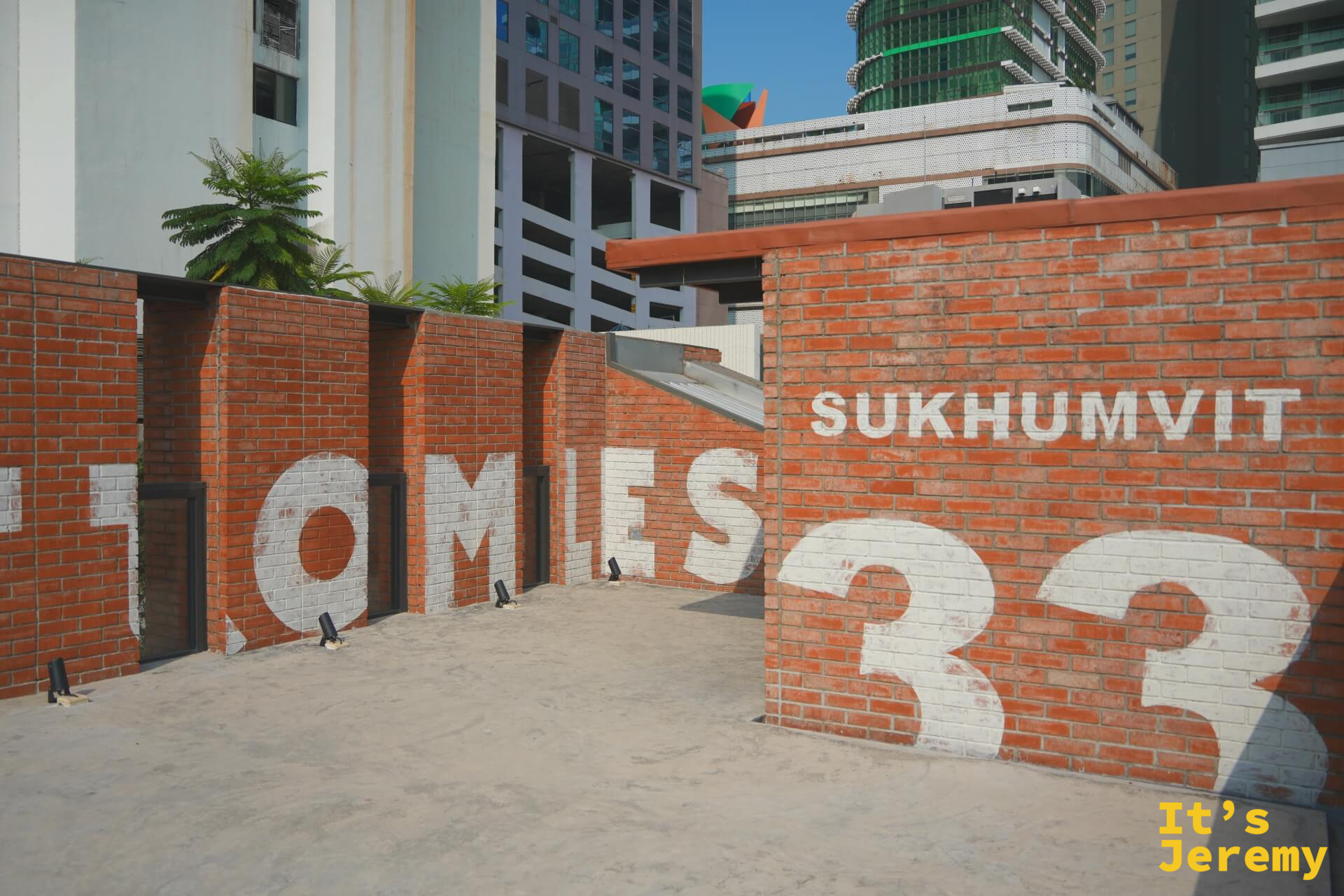 天台「BOTTOMLESS SUKHUMVIT 33」完整字牆,背景曼谷高樓大廈