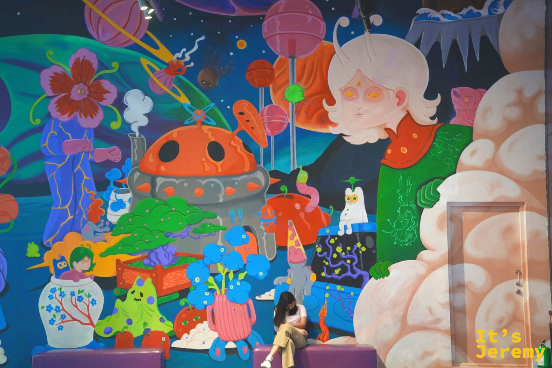 超大型彩色壁畫牆,奇幻生物與宇宙風景,一名女孩坐在牆前