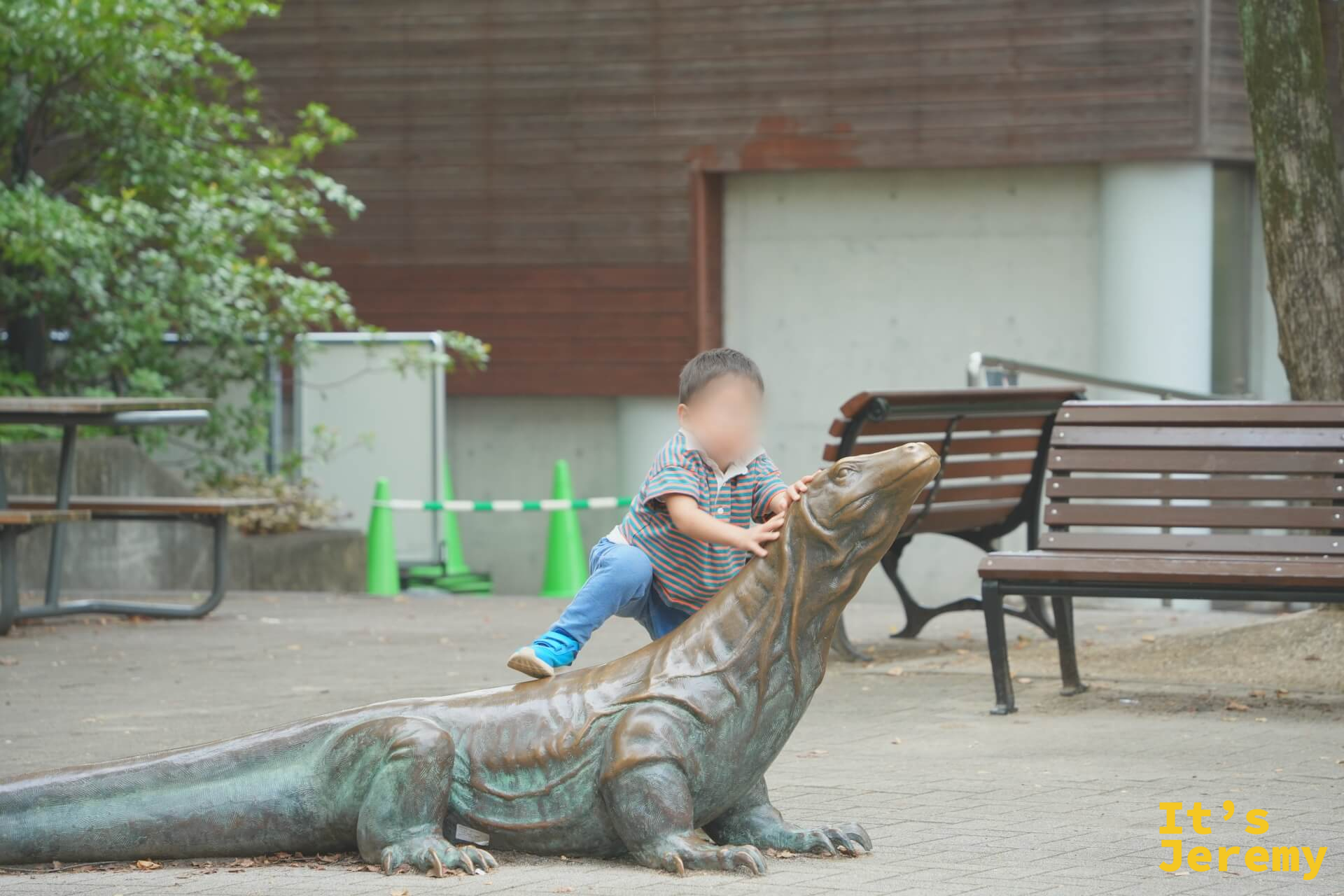 一個小孩爬上科摩多龍銅像的背上玩耍,銅像體型接近真實比例