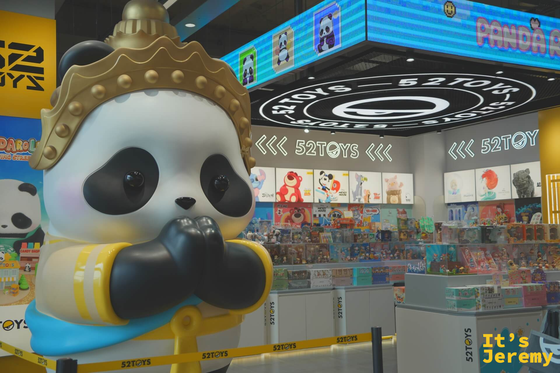 52TOYS 潮玩店,門口巨型熊貓戴泰式金冠雕塑,店內背景是 LED 螢幕和各式盲盒