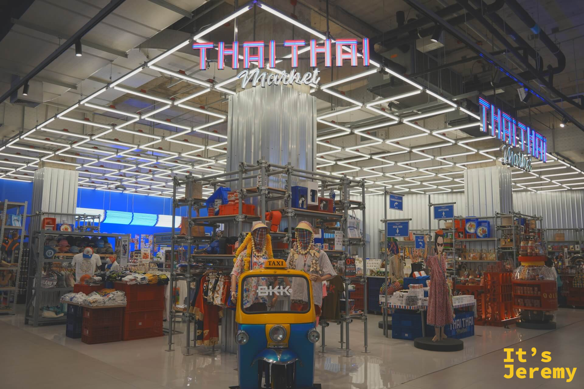 Thai Thai Market 入口全景,霓虹燈管招牌,嘟嘟車裝飾,兩側假人穿著泰式服裝