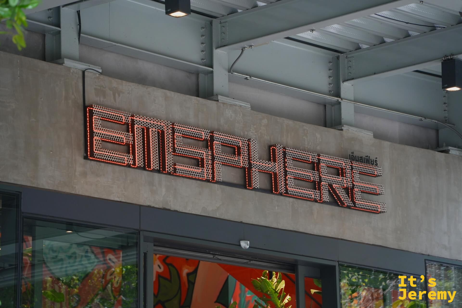 Emsphere 白天外觀,金屬網格字體招牌,泰文「อิมสเฟียร์」刻在水泥牆上