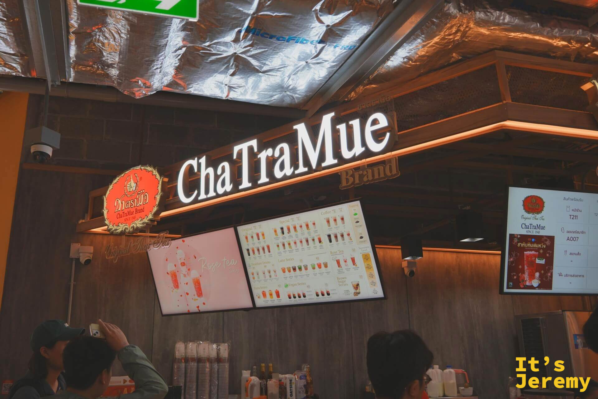 ChaTraMue 手標泰奶店攤位招牌,白色霓虹燈字,旁邊有飲品選單看板