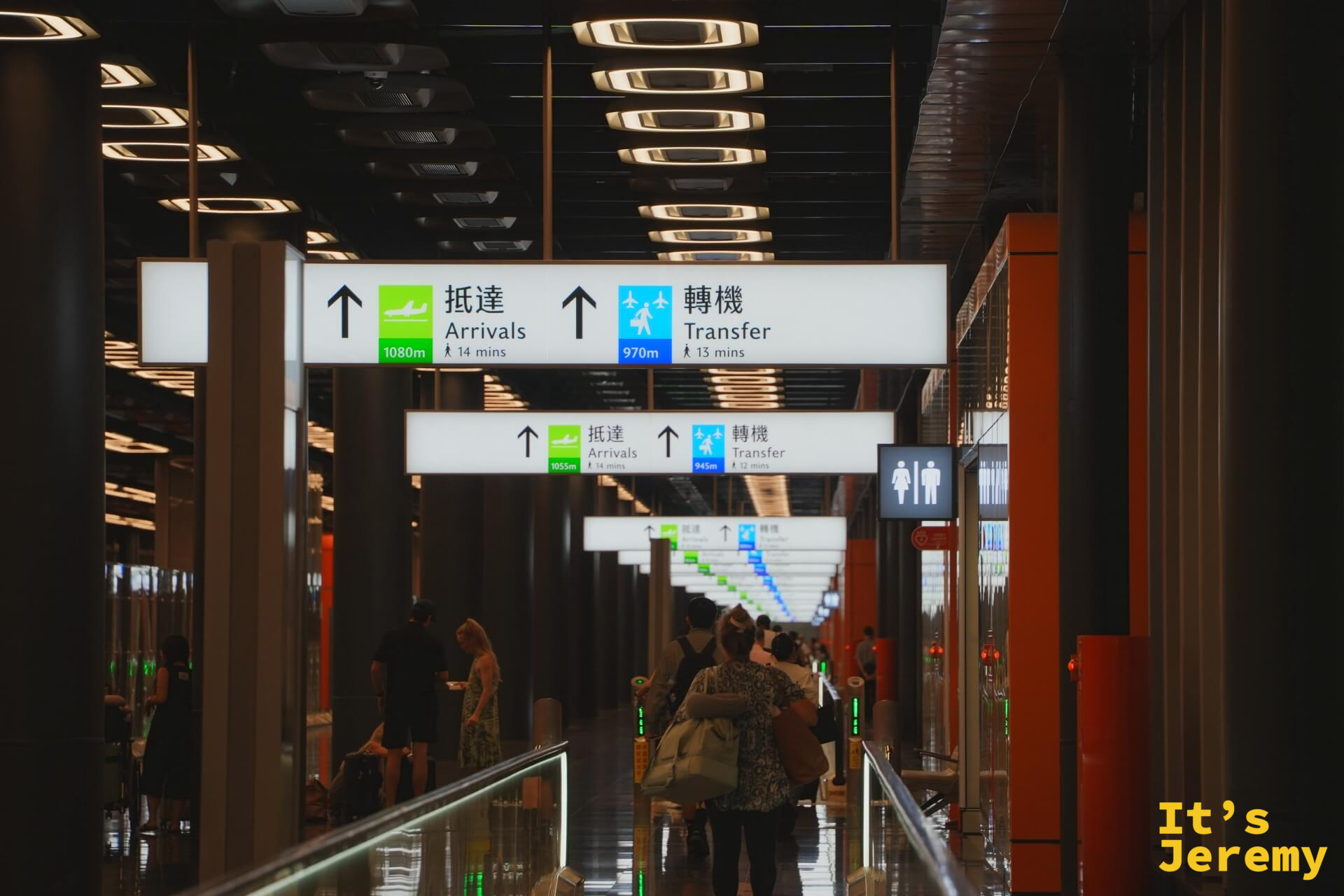 桃園機場第三航廈入境走廊,抵達 Arrivals 和轉機 Transfer 指示看板,旅客正在行走