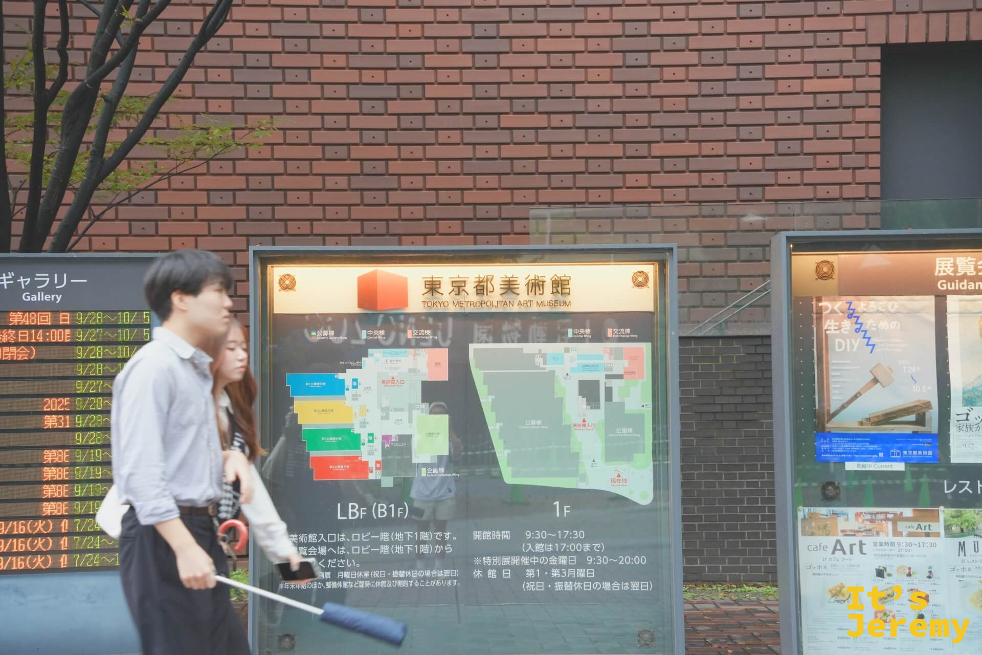 東京都美術館外的展覽告示牌，顯示館區地圖和開館時間，前方有行人路過，右側看板可見梵谷展的宣傳