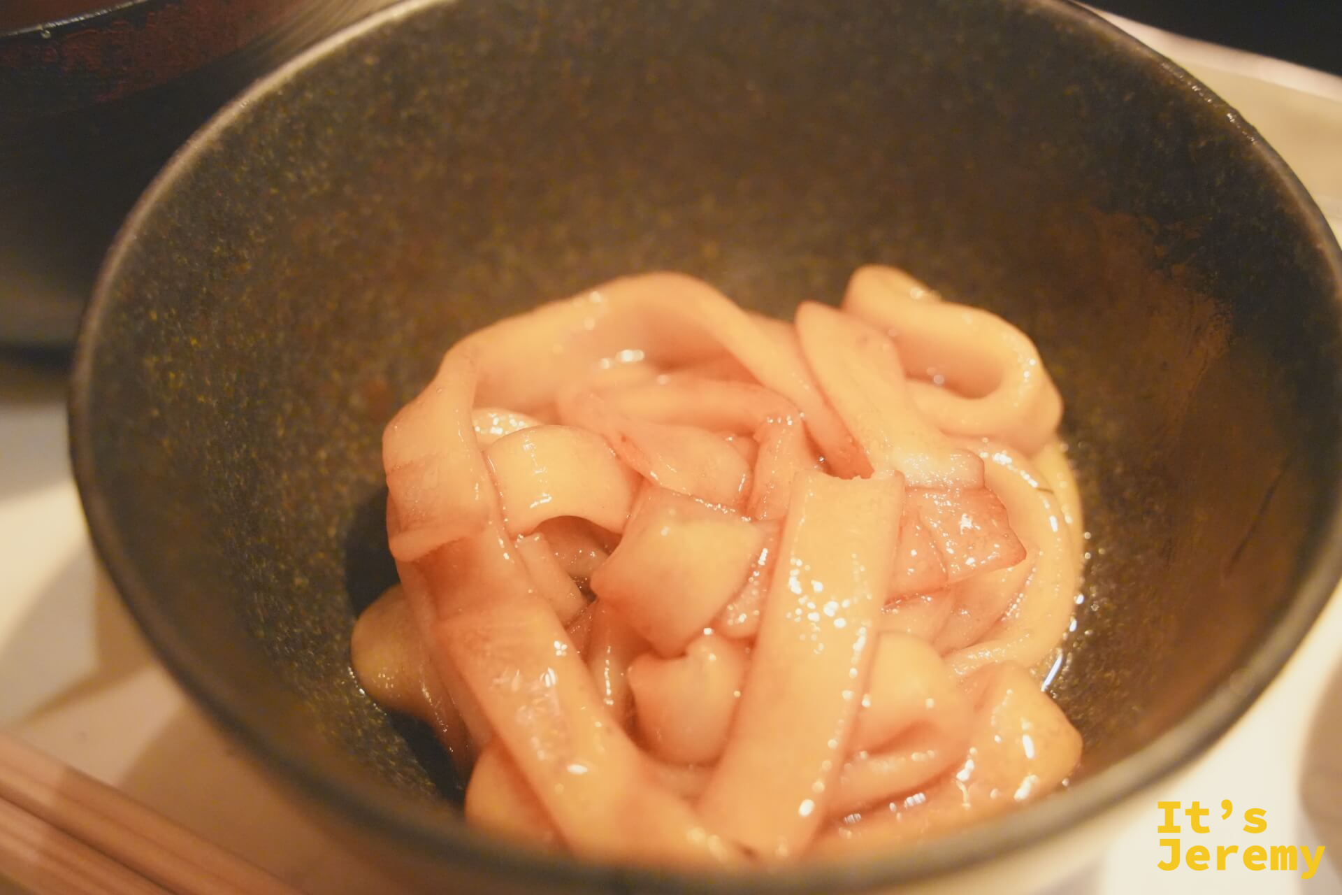 締め麵料理,捲曲麵條盛在深色陶碗中