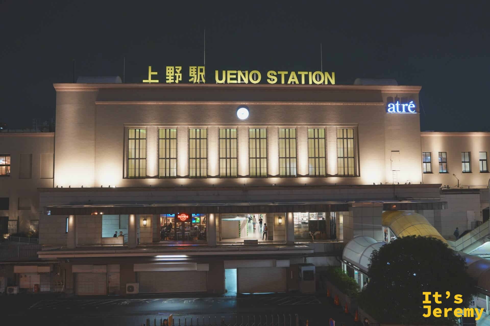 上野站夜間站體外觀，「上野駅 UENO STATION」金色大字在夜燈下清晰，atre 招牌亮著藍光，站前廣場安靜而有秩序