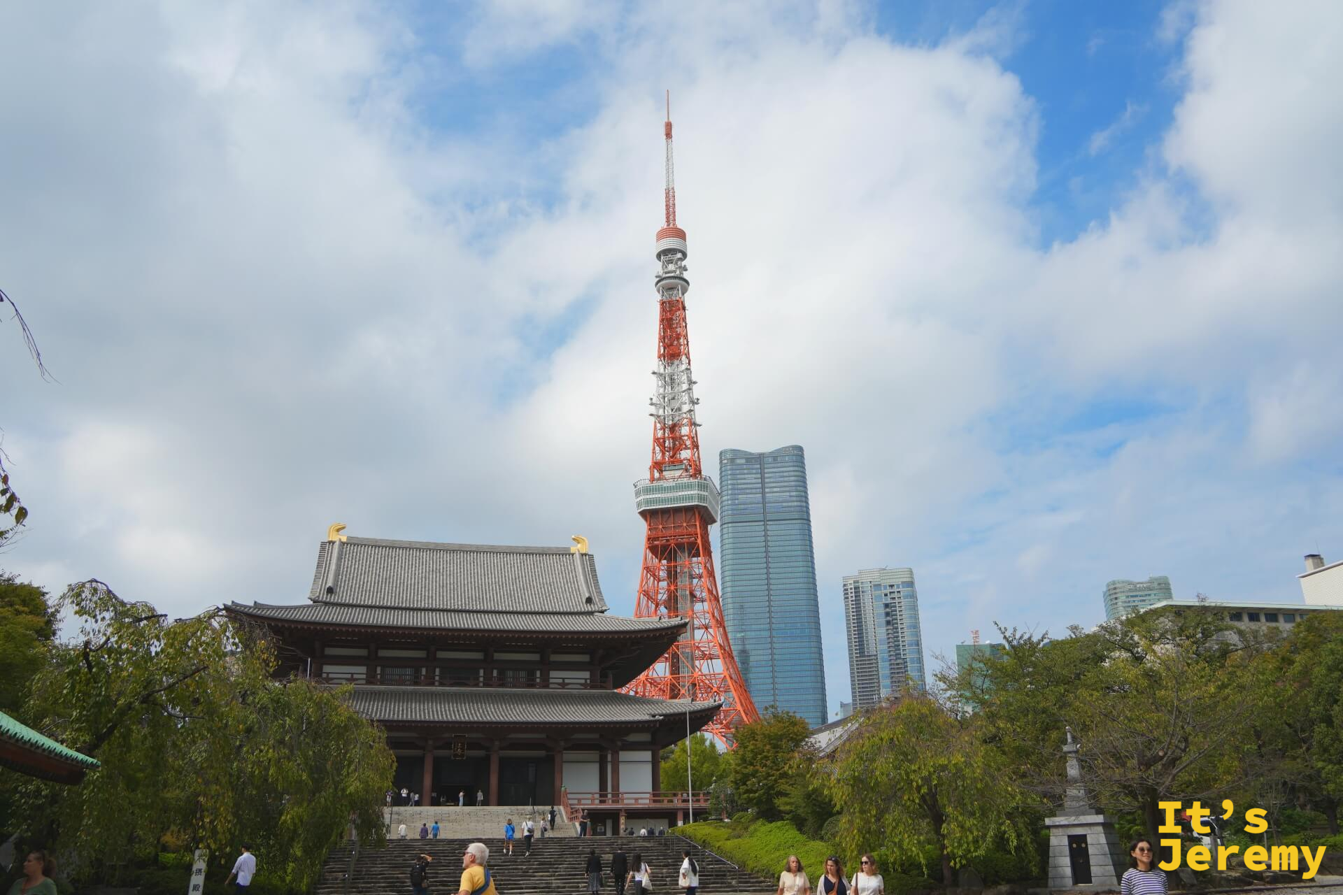 増上寺大殿正面,後方東京鐵塔聳立,台階前往來的遊客
