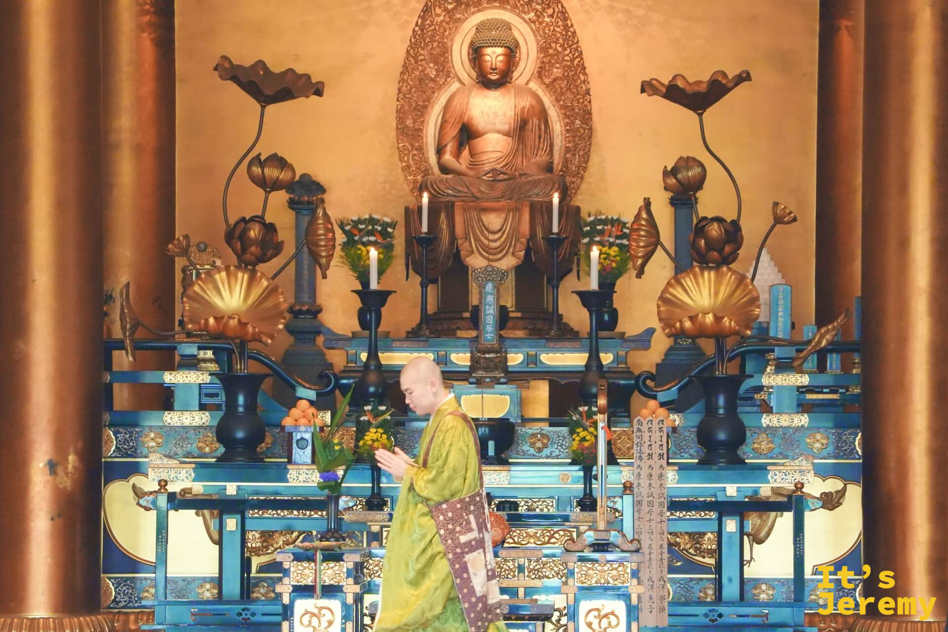 増上寺大殿內,僧侶身著黃綠法袍在金色佛壇前緩步行走
