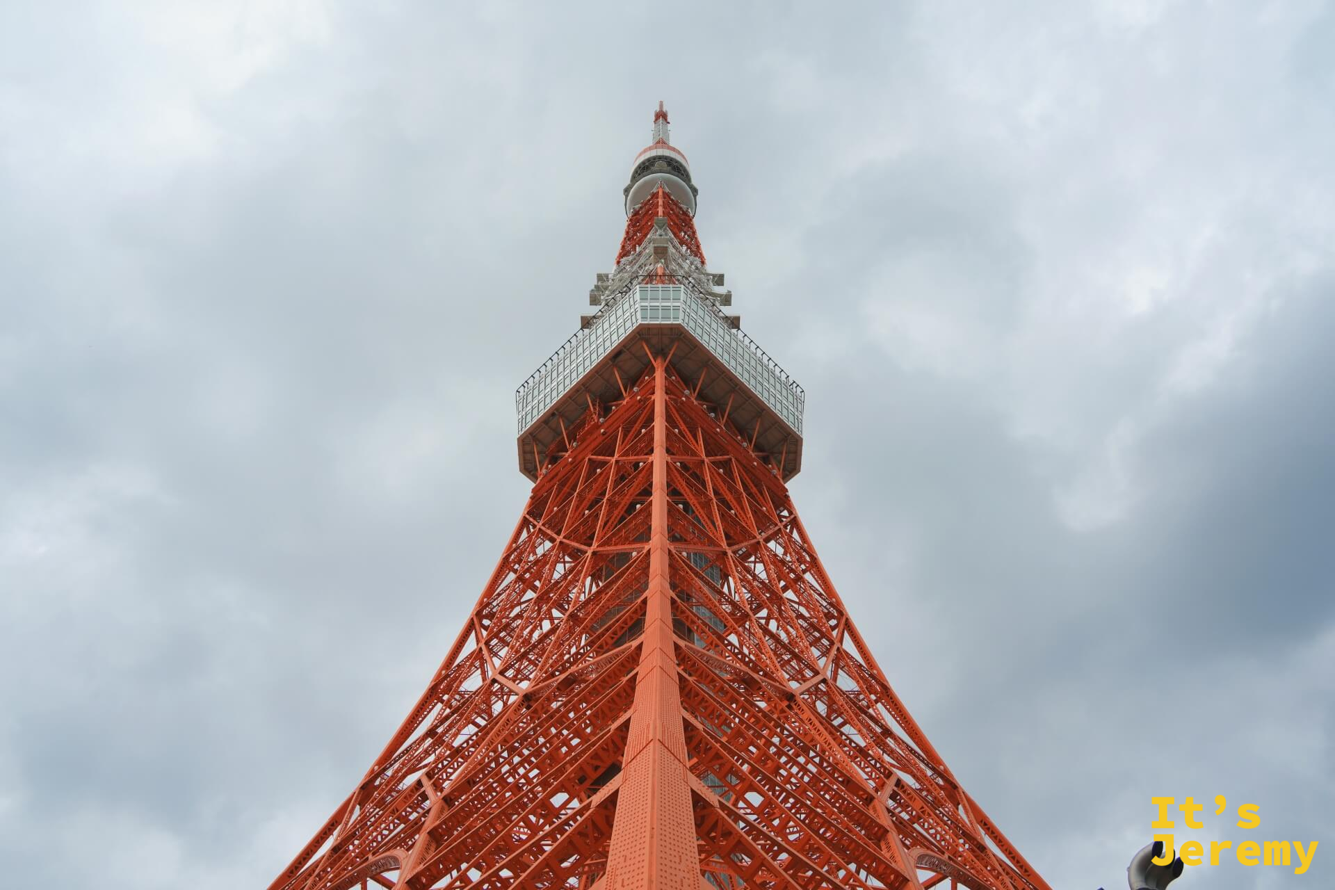 從赤羽橋路口仰頭,東京鐵塔正面全景,橘紅鐵架筆直衝向灰白天空
