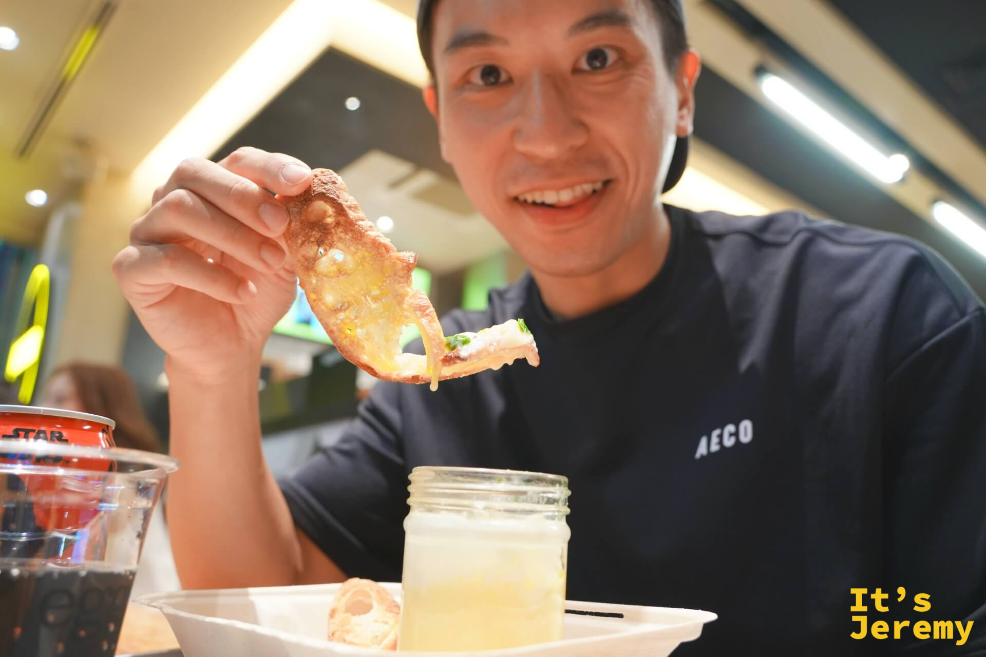 Jeremy 舉著一片沾了蛋黃的薄餅，SLUT 玻璃罐在前方桌上