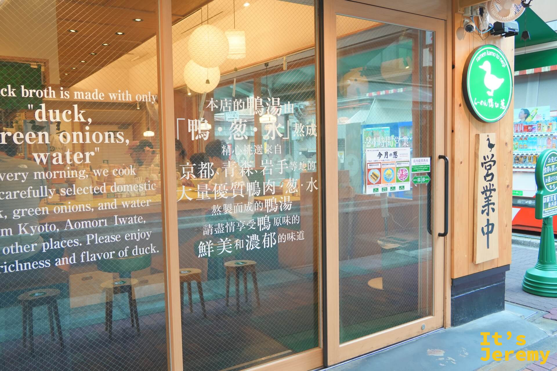 店門玻璃特寫,貼著「本店的鴨湯由鴨・蔥・水熬成」中日英三語說明