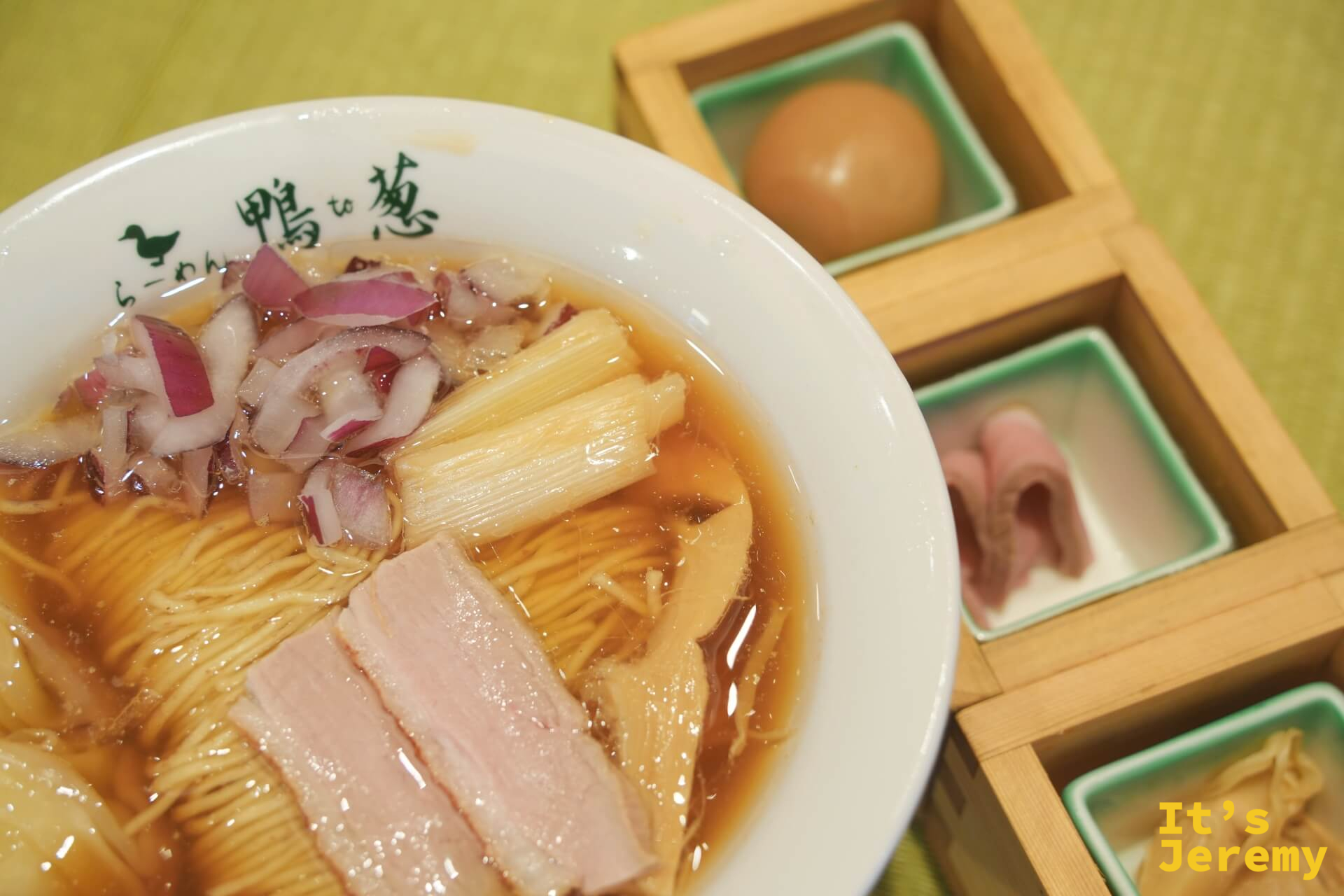 鴨らーめん特上近景,清醬油湯底,鴨肉片與紅洋蔥鋪在上方,木盒裝著溏心蛋和鴨コンフィ