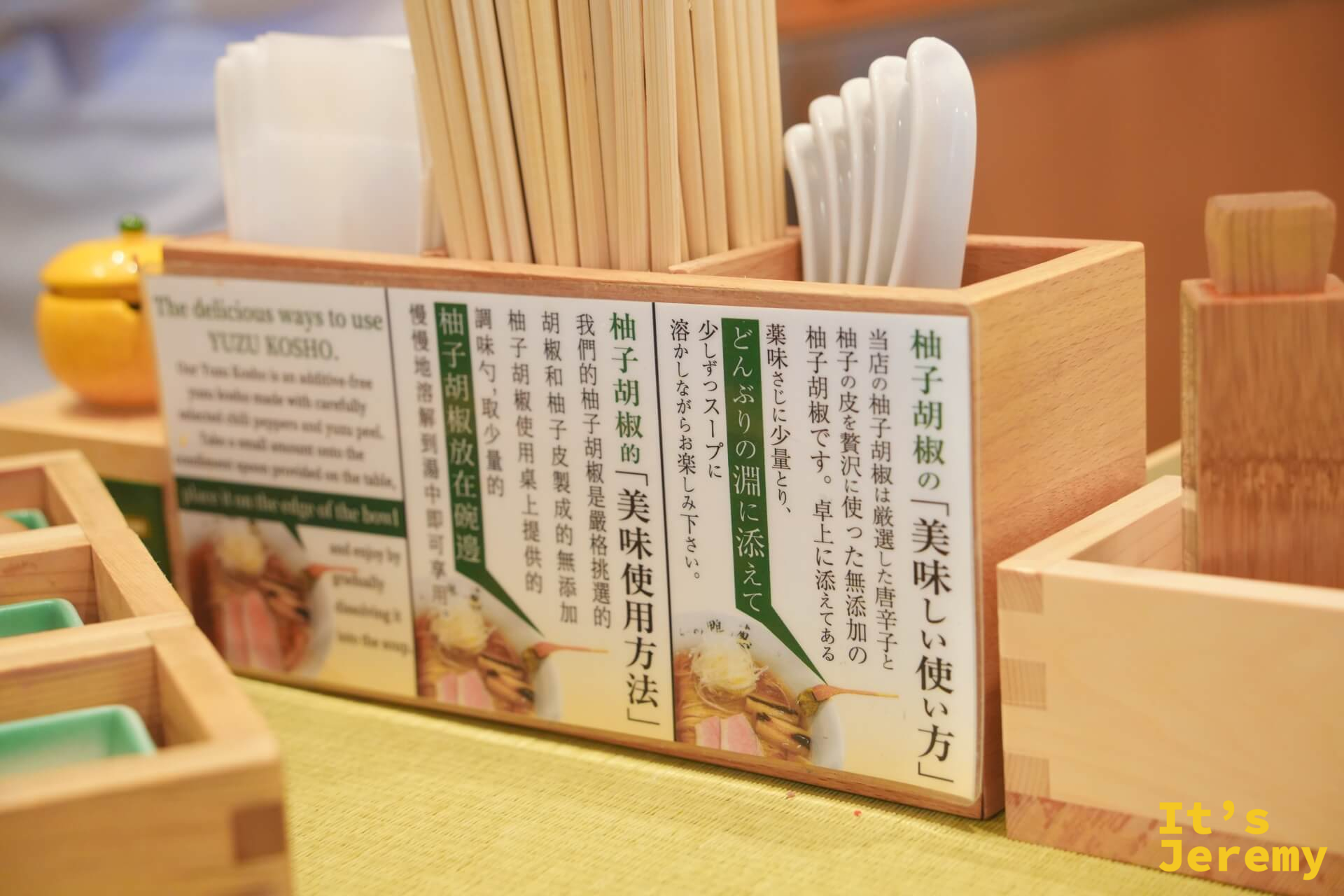 桌上的柚子胡椒說明牌,旁邊擺著一個完整柚子和筷架湯匙架
