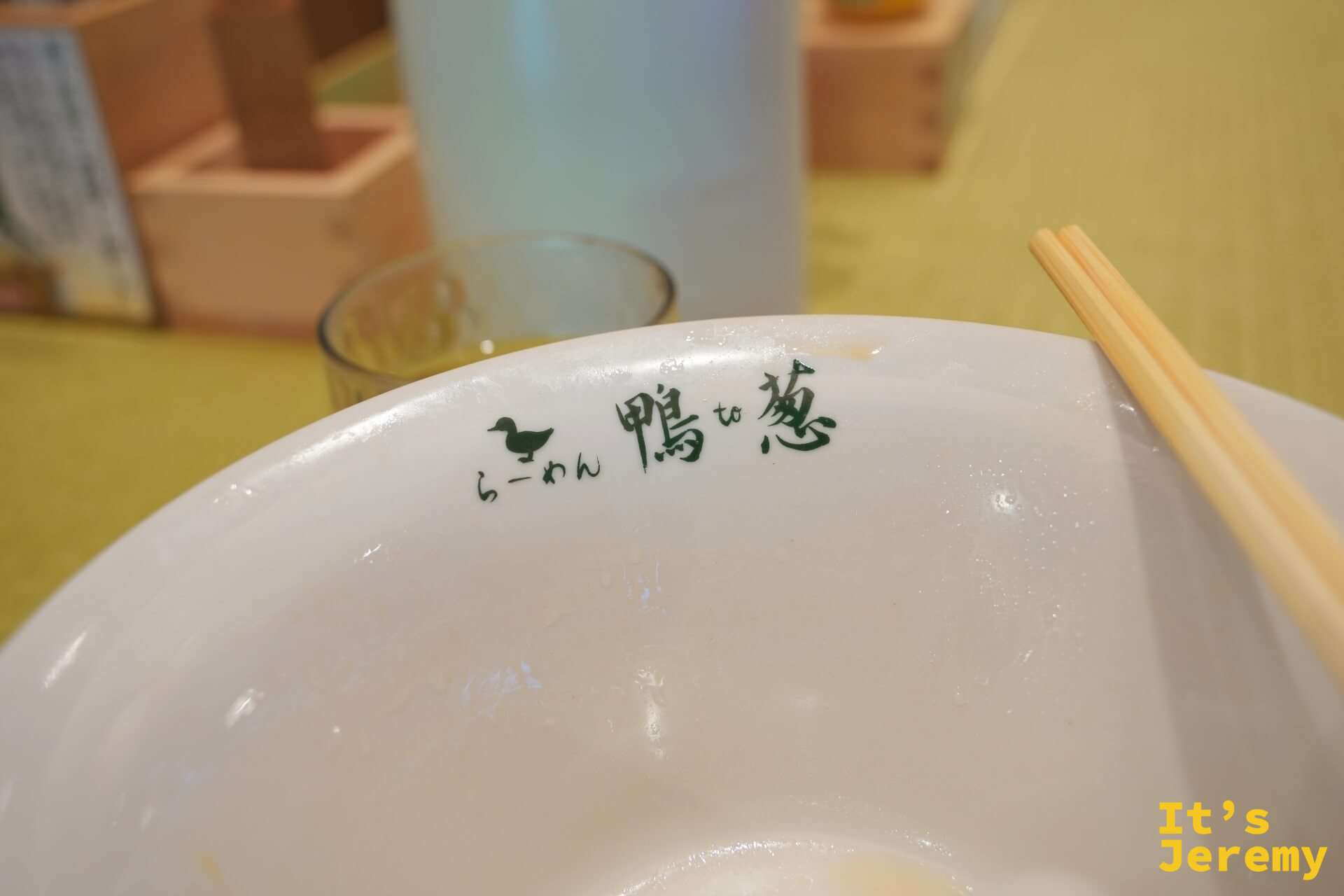 吃完後的空碗,碗沿刻著「らーめん鴨to葱」logo,一雙筷子斜放