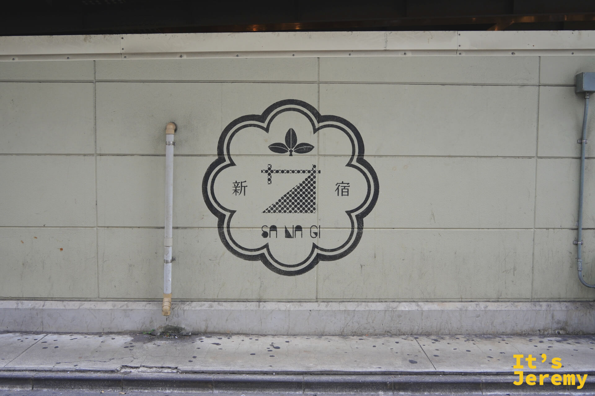 新宿 SANAGI 品牌 Logo 印在建築外牆的灰白瓷磚上,圓框紋樣帶有和式設計感
