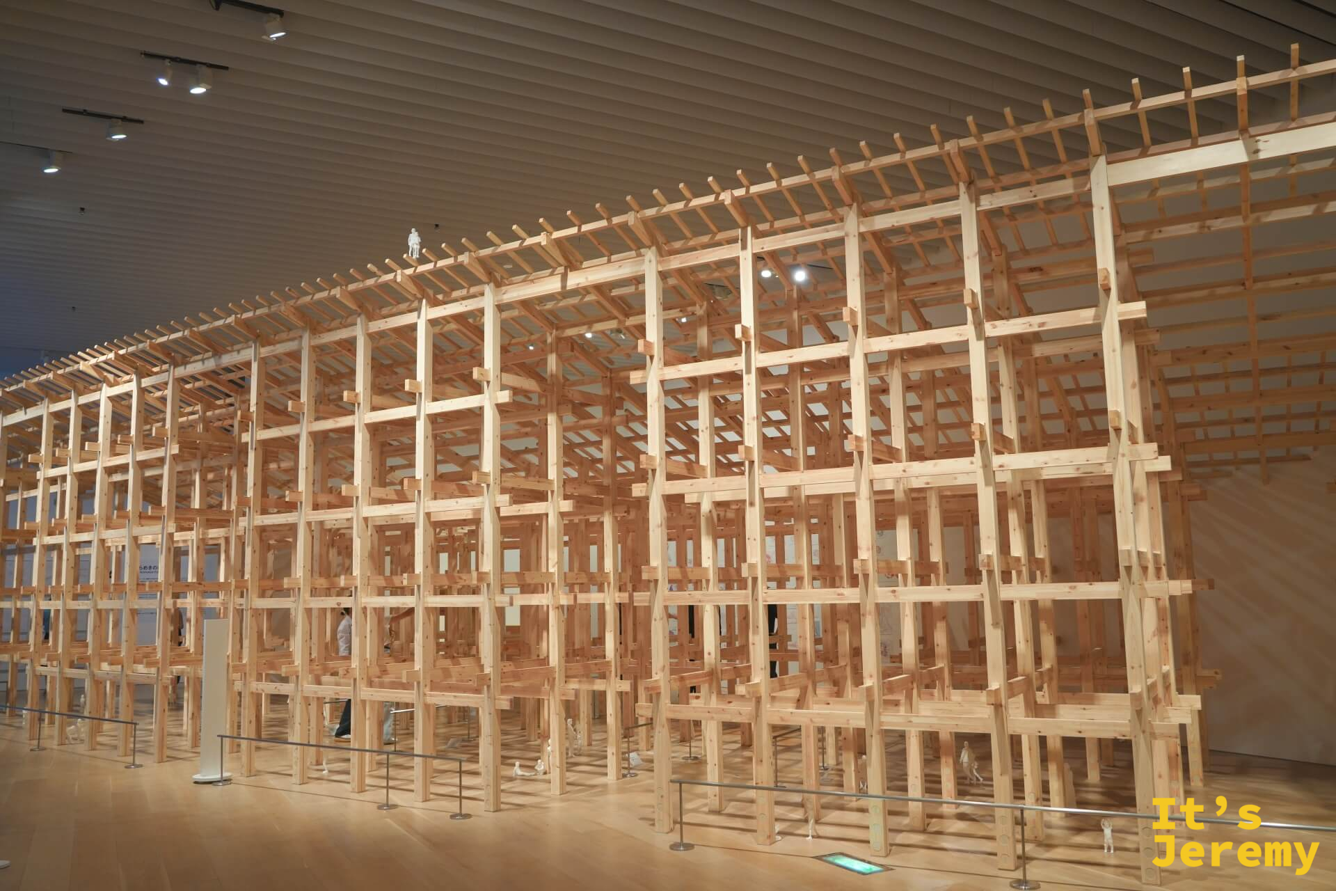 藤本壯介個展展廳全景：大型原木骨架裝置填滿整個展廳，高聳至天花板