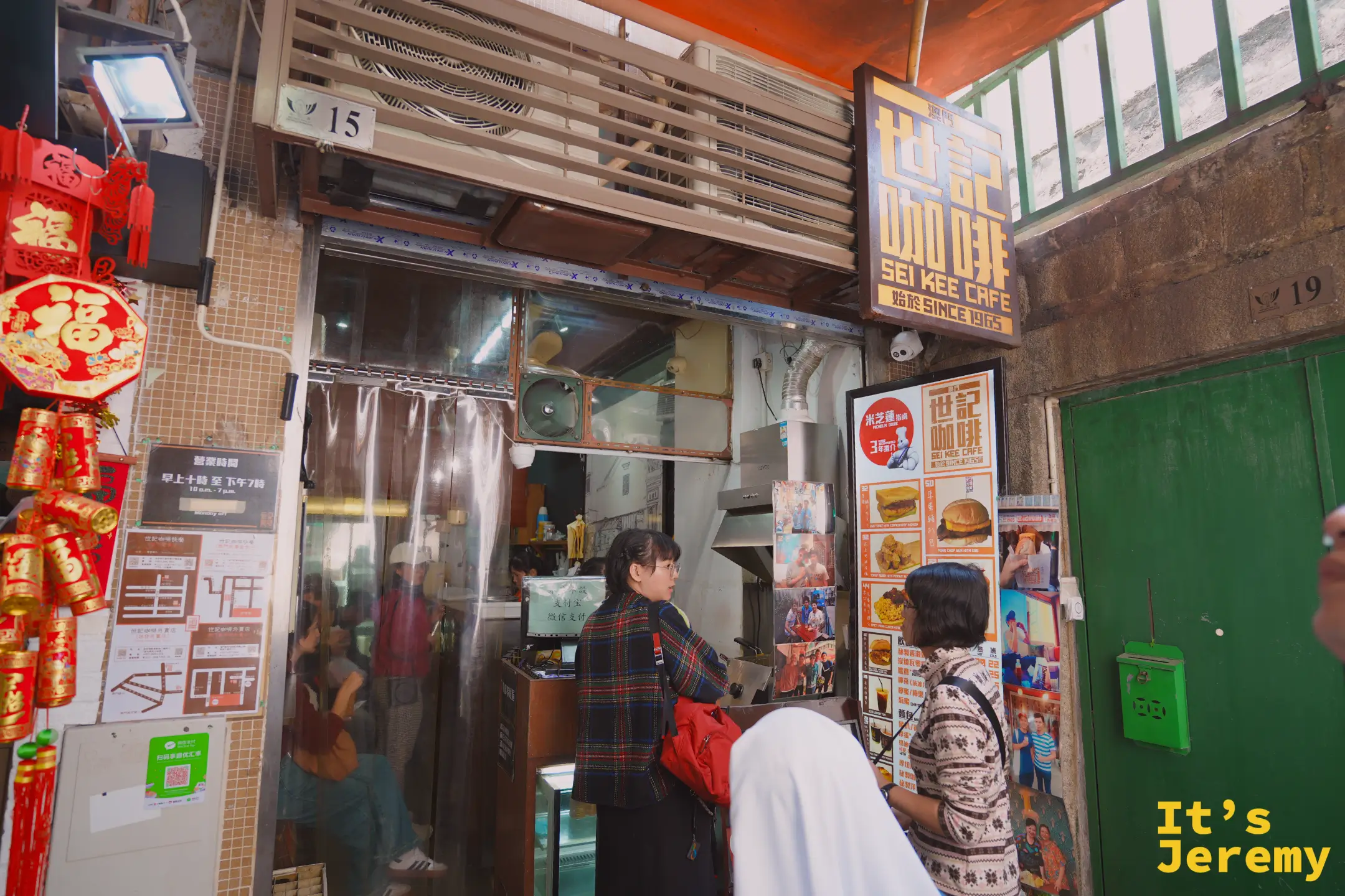 世記咖啡大三巴店的店面，橘色招牌寫著 SEI KEE CAFE，客人在窗口前點餐