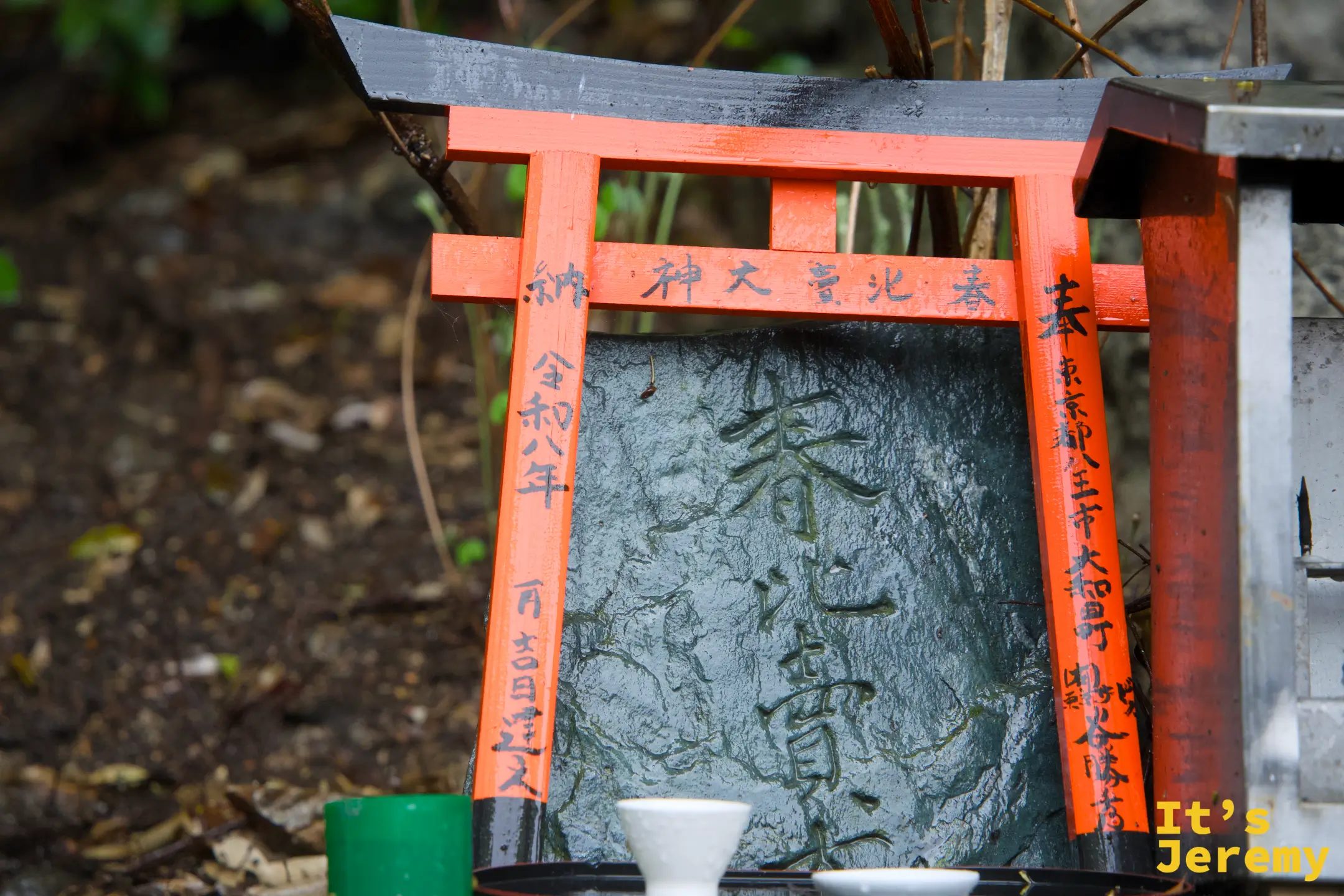 山路旁，有人在迷你鳥居供台前擺上茶碗作為供品