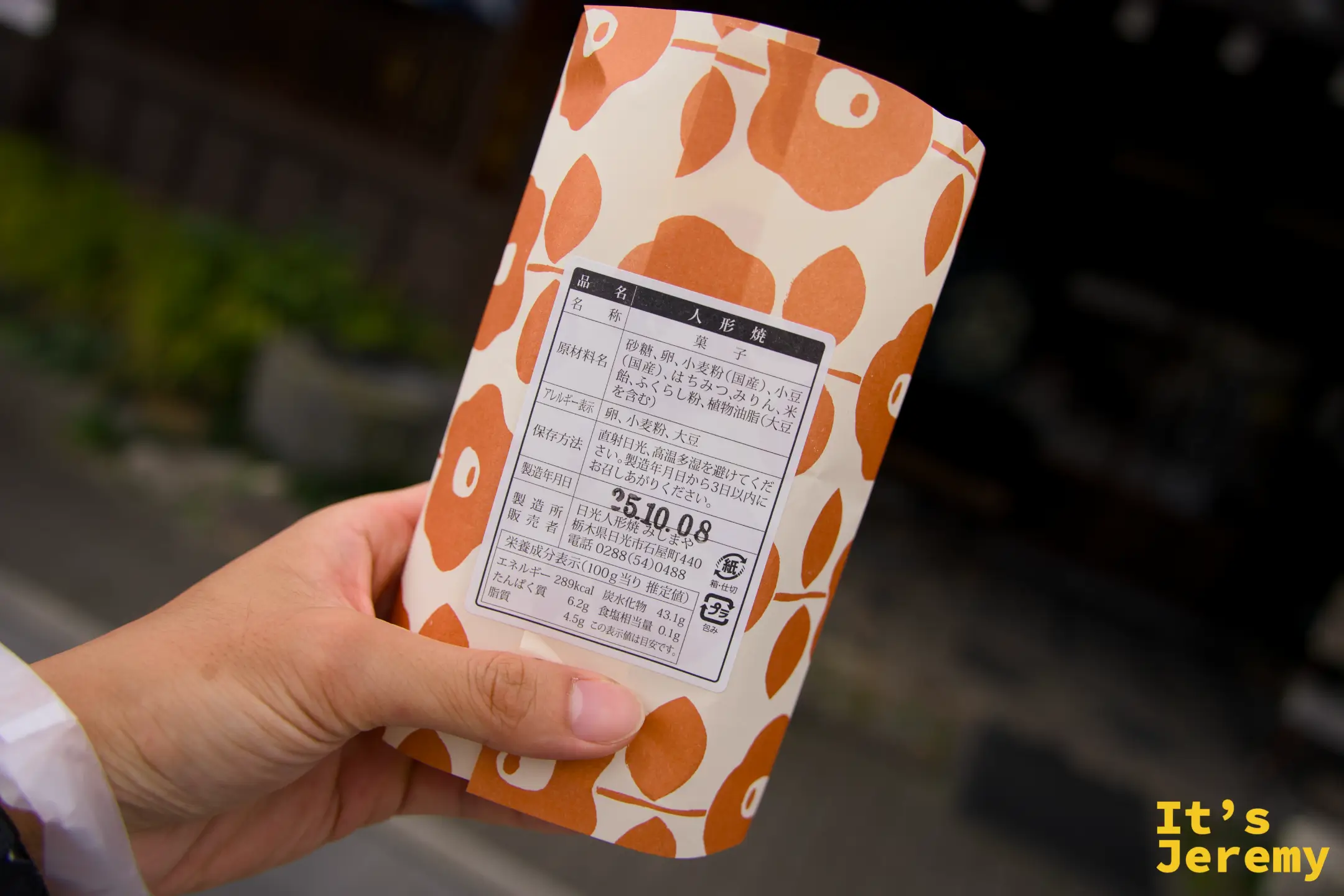 手持人形焼みしまや 橘色印花包裝袋背面，印有成分標示與製造所「日光人形焼みしまや」