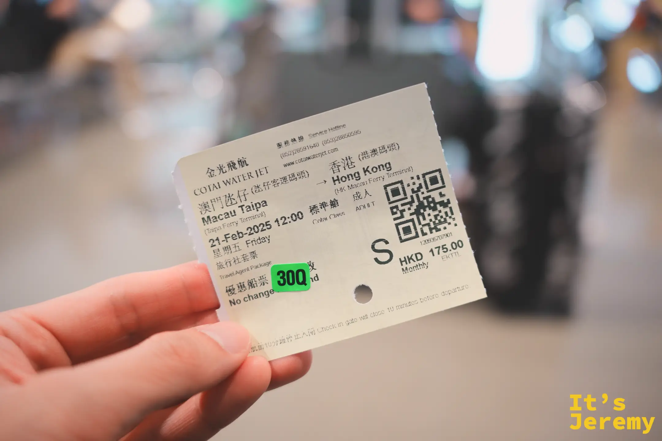 手裡拿著金光飛航的船票，Macau Taipa 往 Hong Kong，票面印著 21-Feb-2025、標準艙 HKD 175