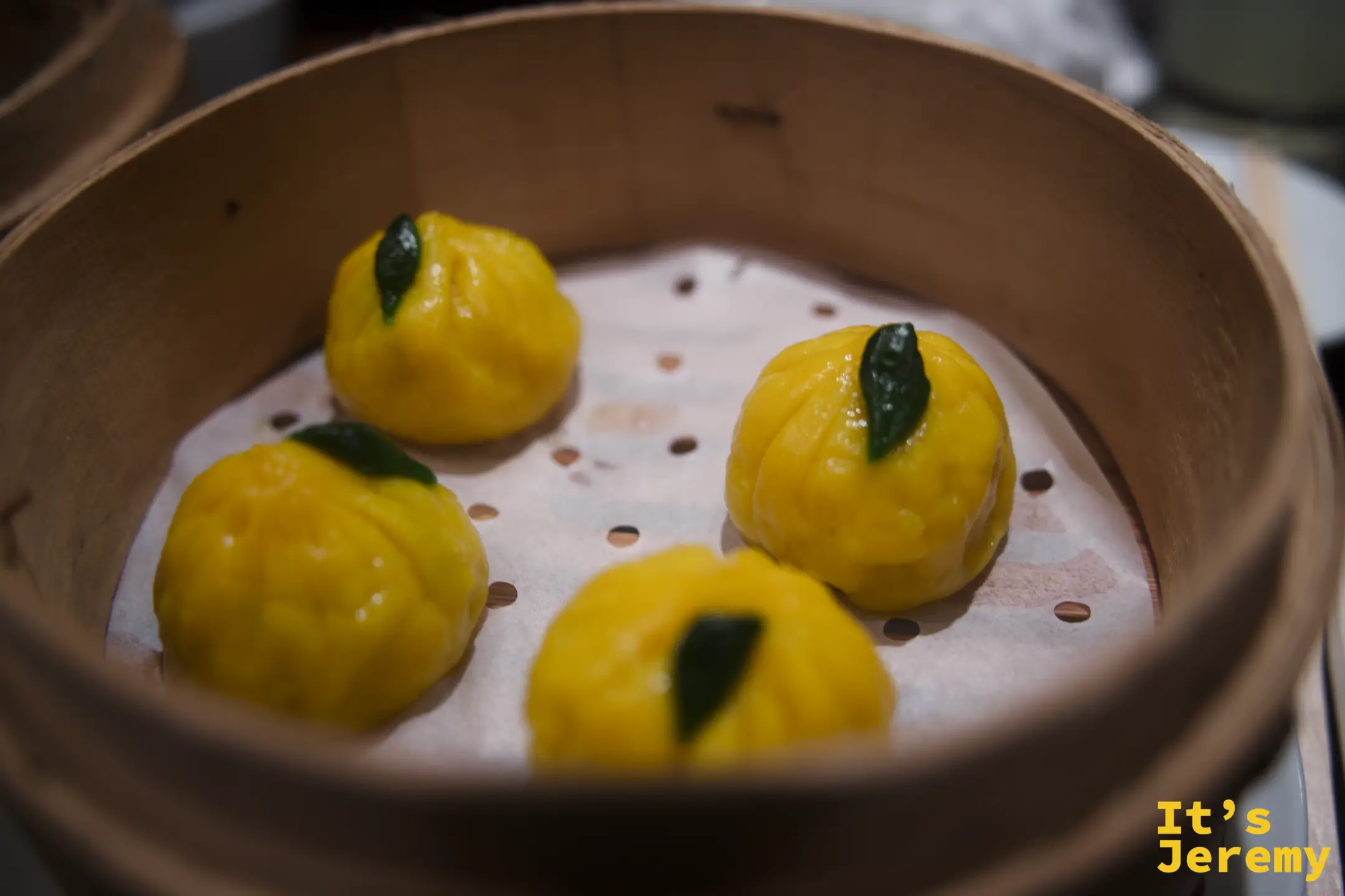 黃柚子餃子,外皮金黃飽滿,盛在蒸籠裡