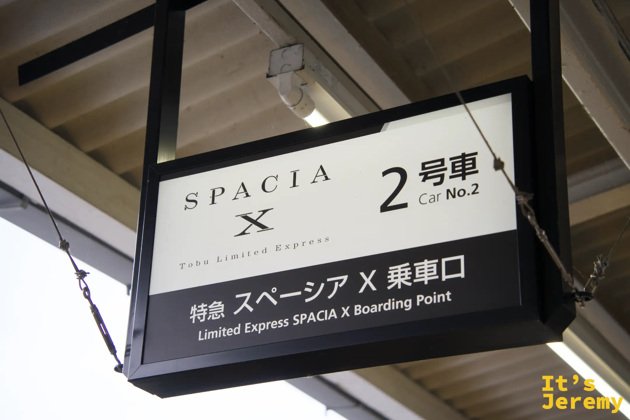 月台天花板懸掛「SPACIA X 2号車 Car No.2，特急スペーシアX乗車口 Limited Express SPACIA X Boarding Point」標示牌