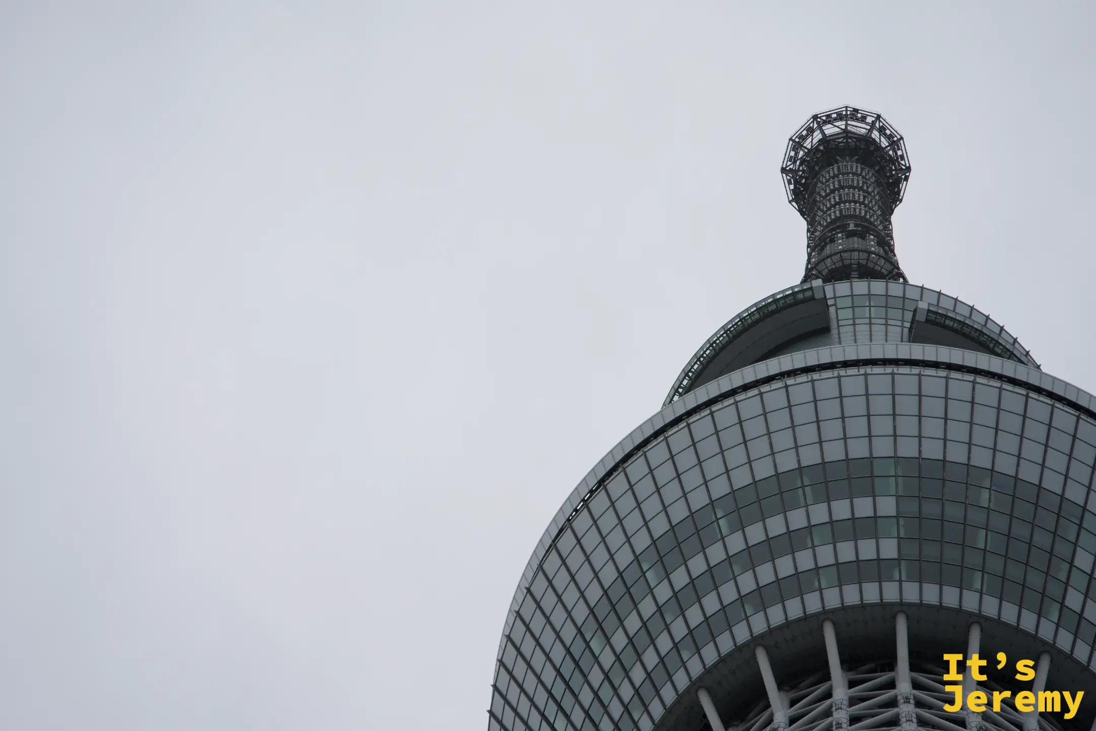 晴空塔天望台球形結構與上方細長天線近景,玻璃格紋清晰,輪廓乾淨俐落