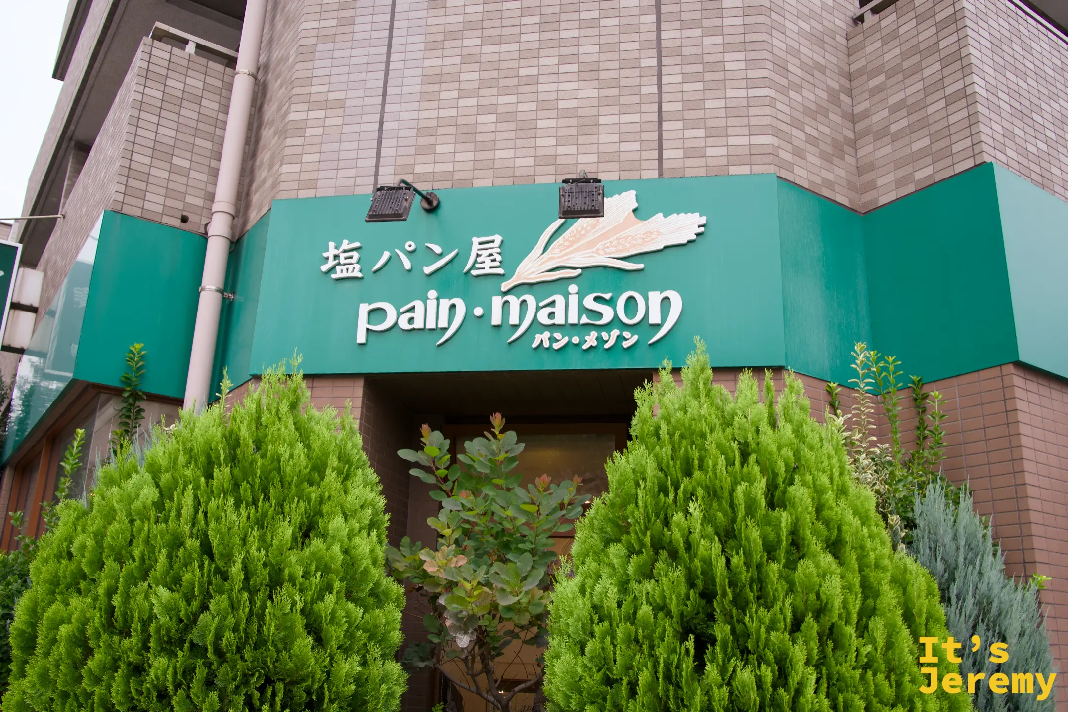 Pain Maison 店外正面，綠色招牌與入口植栽