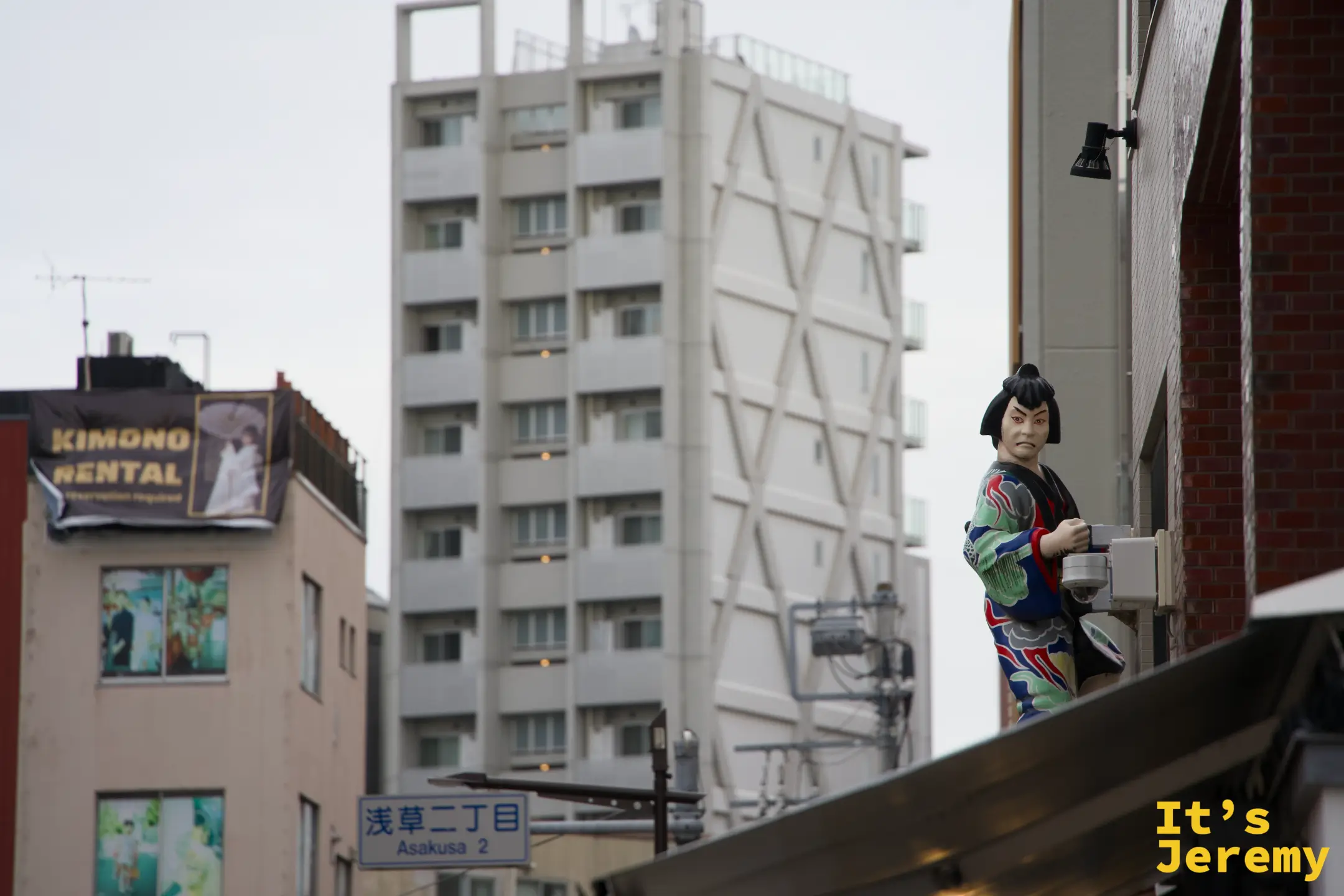 浅草二丁目路口，建築屋頂上的歌舞伎人偶俯瞰街道，KIMONO RENTAL招牌清晰可見
