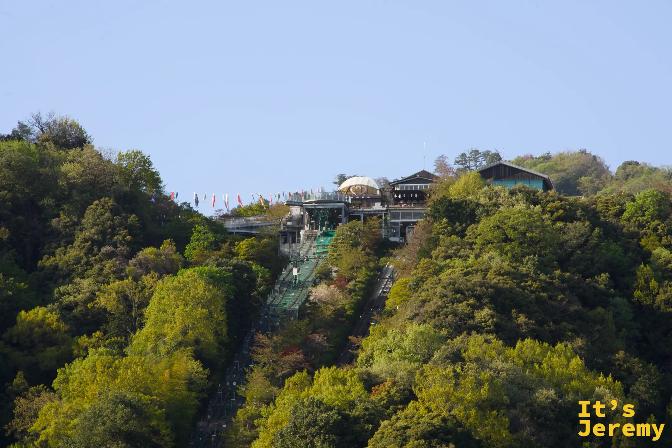 船上から傘松公園の山とリフトを望む