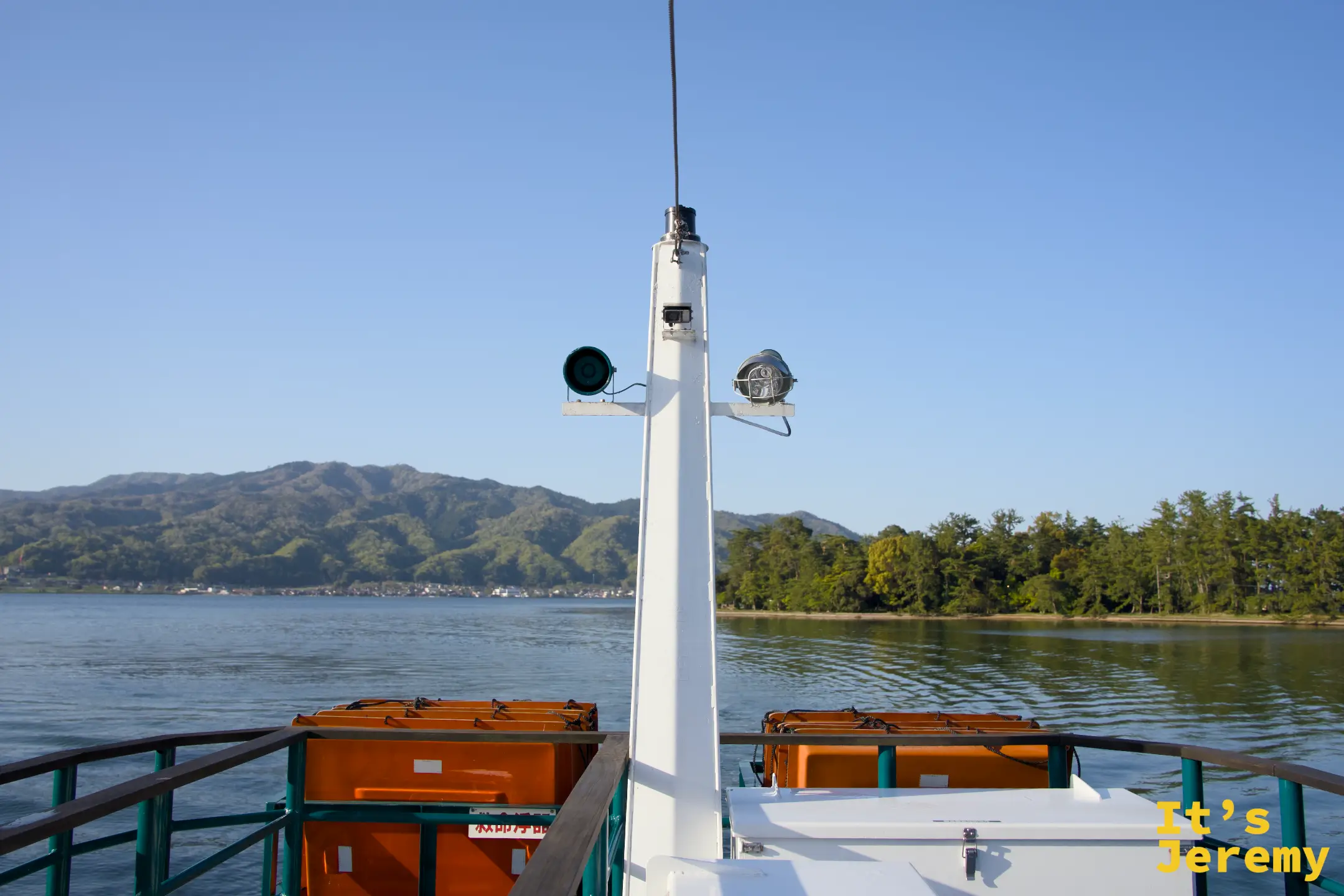 交通船の船首から天橋立の松林と山を見る