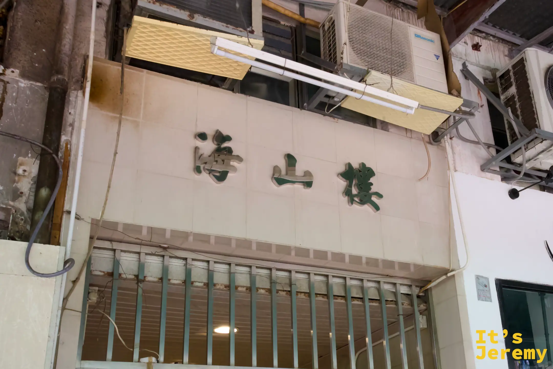 白色牆面上掛著「海山樓」綠色立體字招牌，旁邊是冷氣機與日光燈管