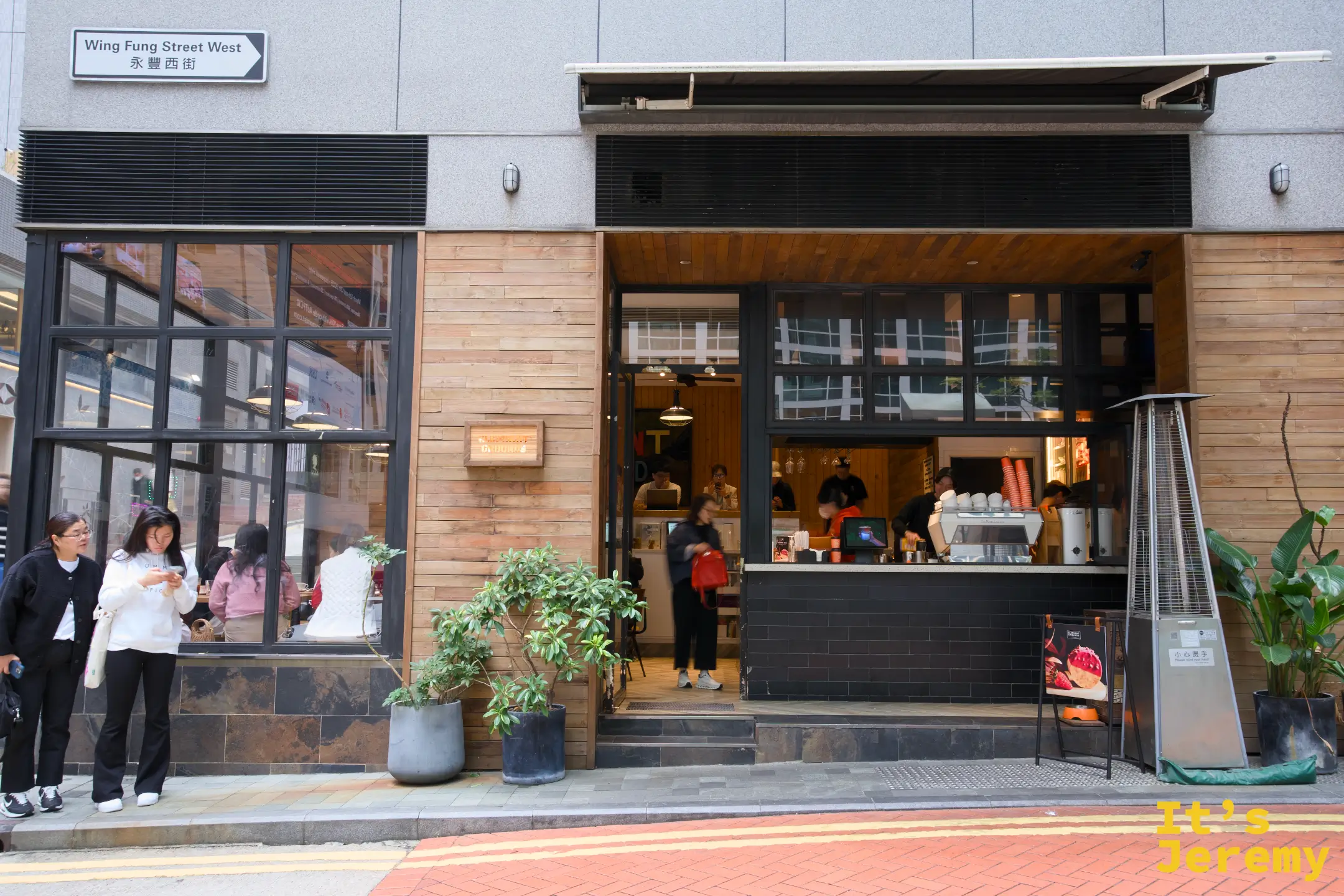 店面外觀，木質外牆與大片落地窗，門口有「永豐西街 Wing Fung Street West」路牌