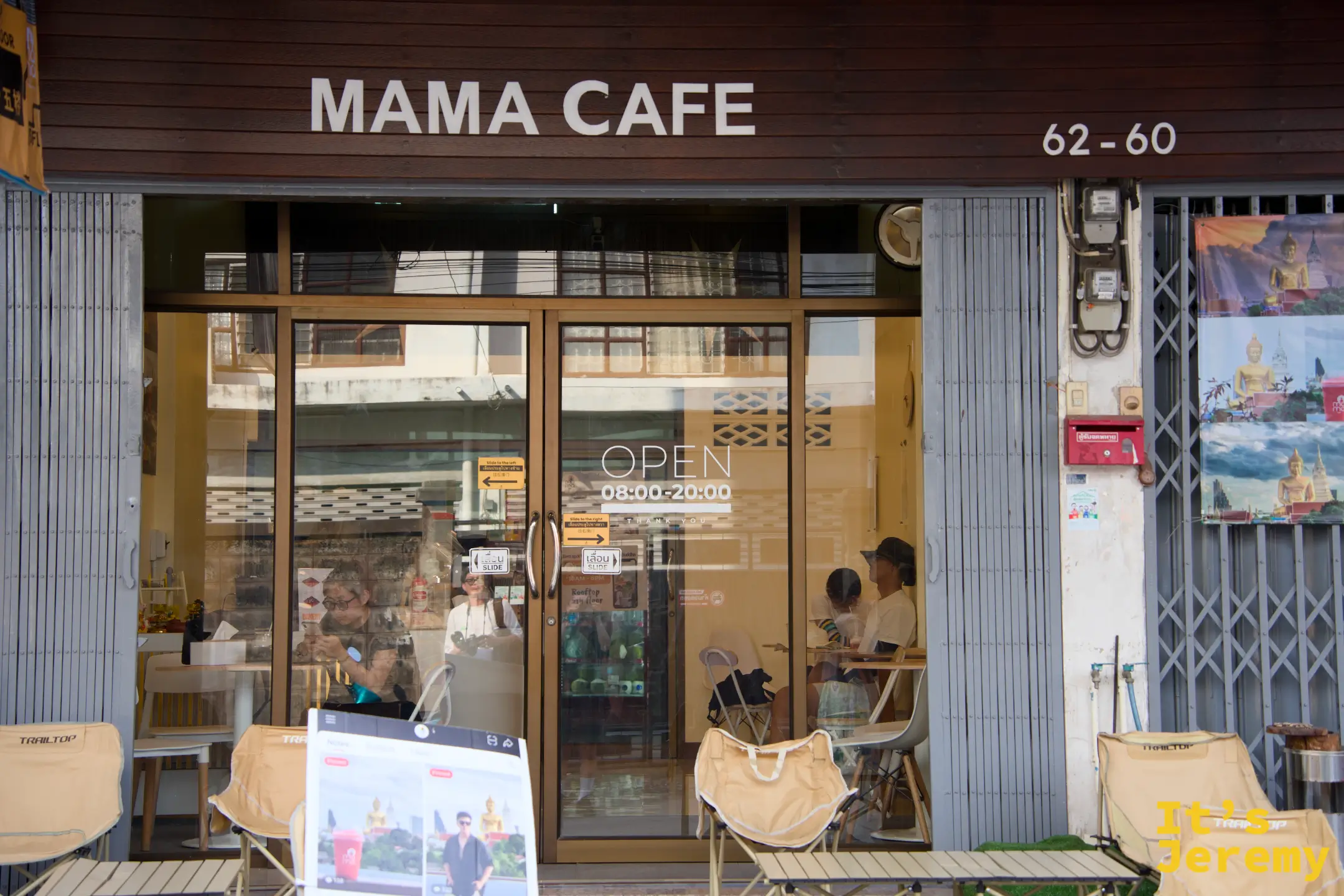 MAMA Café 店面外觀，木質感招牌標示營業時間 08:00–20:00，戶外擺著帆布摺疊椅，低調得不像全曼谷視野最強的咖啡廳