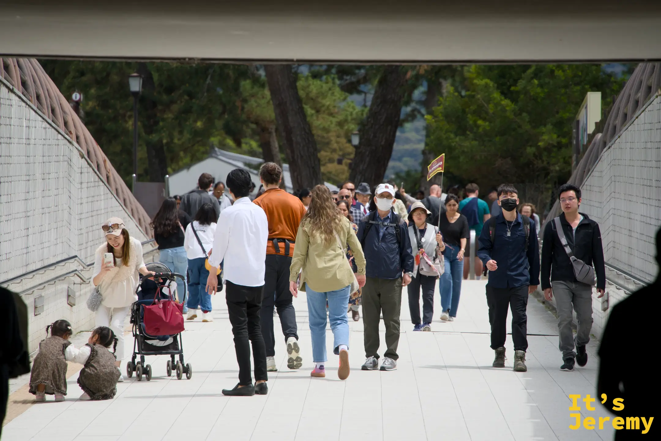 遊客穿過石砌通道走向公園深處