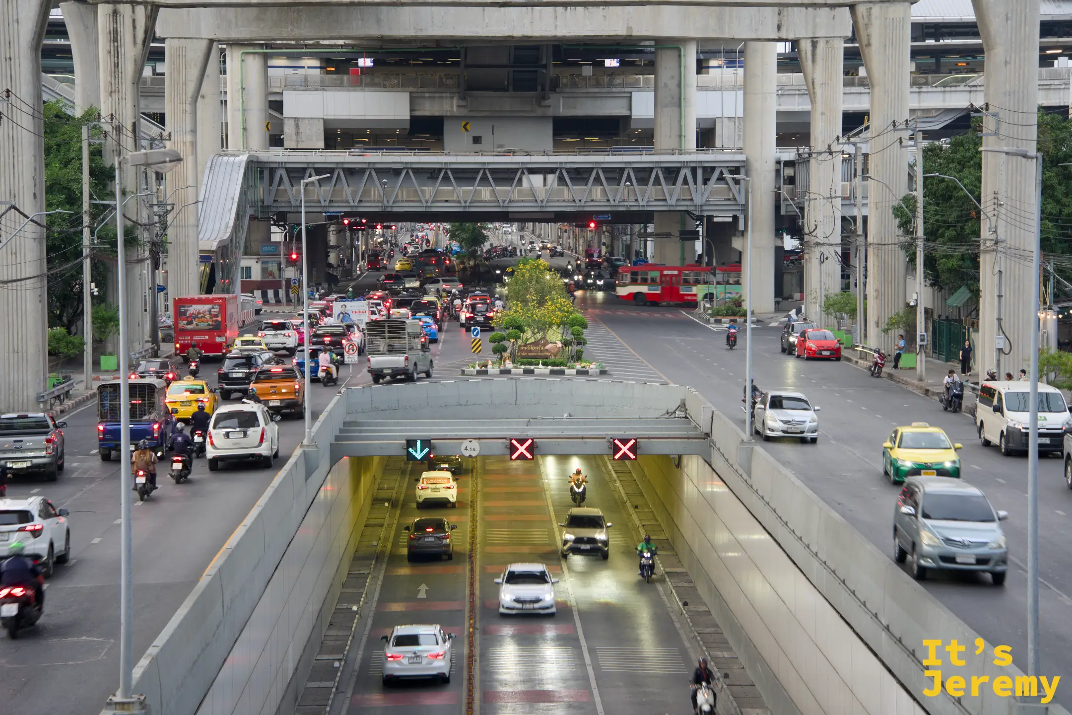 傍晚的 Talat Phlu 站前大道，捷運高架橋下車水馬龍，車輛駛入隧道，吞武里的一天在這裡換檔