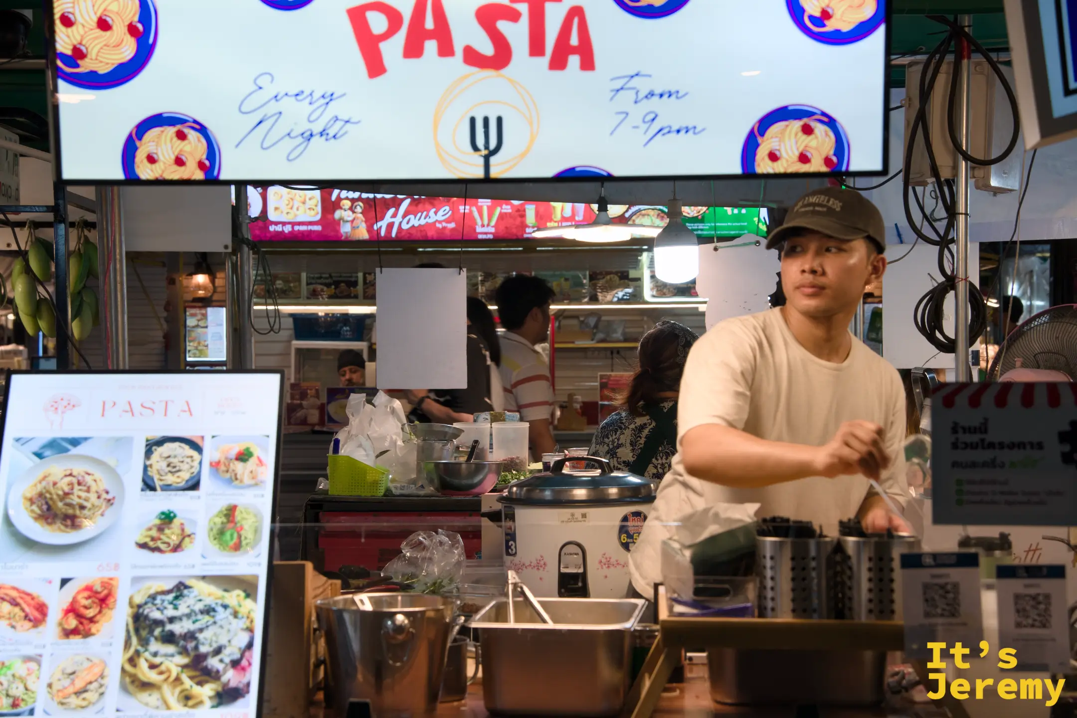 Talat Phlu 夜市內的一家現做義大利麵攤位，招牌寫著每晚 7 到 9 點營業，前方擺有精美菜單。