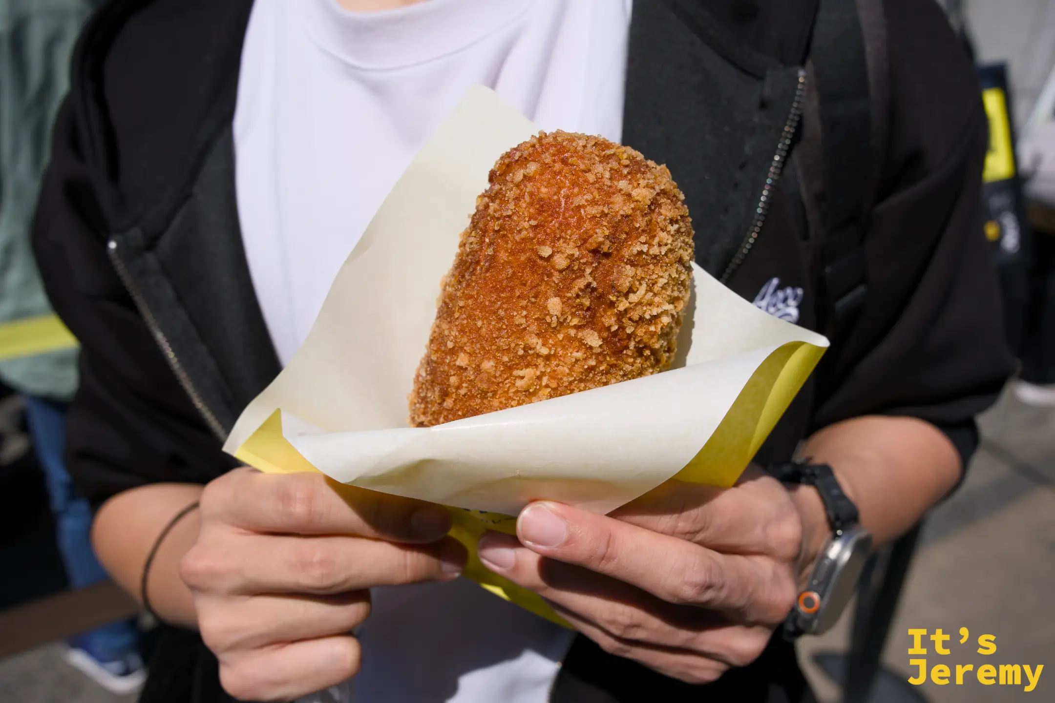 ジラッファ的咖哩麵包特寫，深褐麵包皮外層酥脆，用黃色紙包盛著，份量紮實