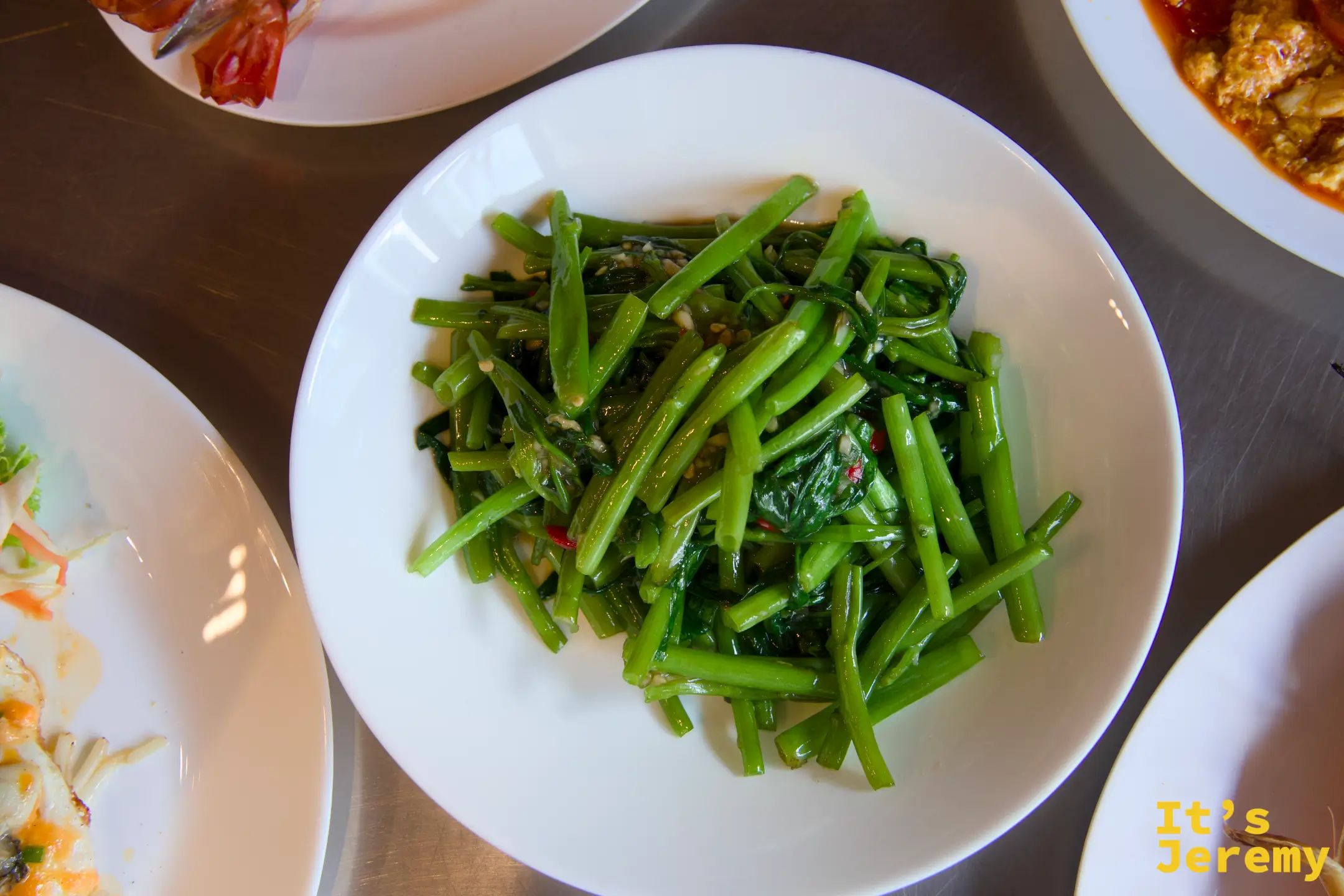 清炒空心菜特寫，翠綠菜梗盛在白盤中