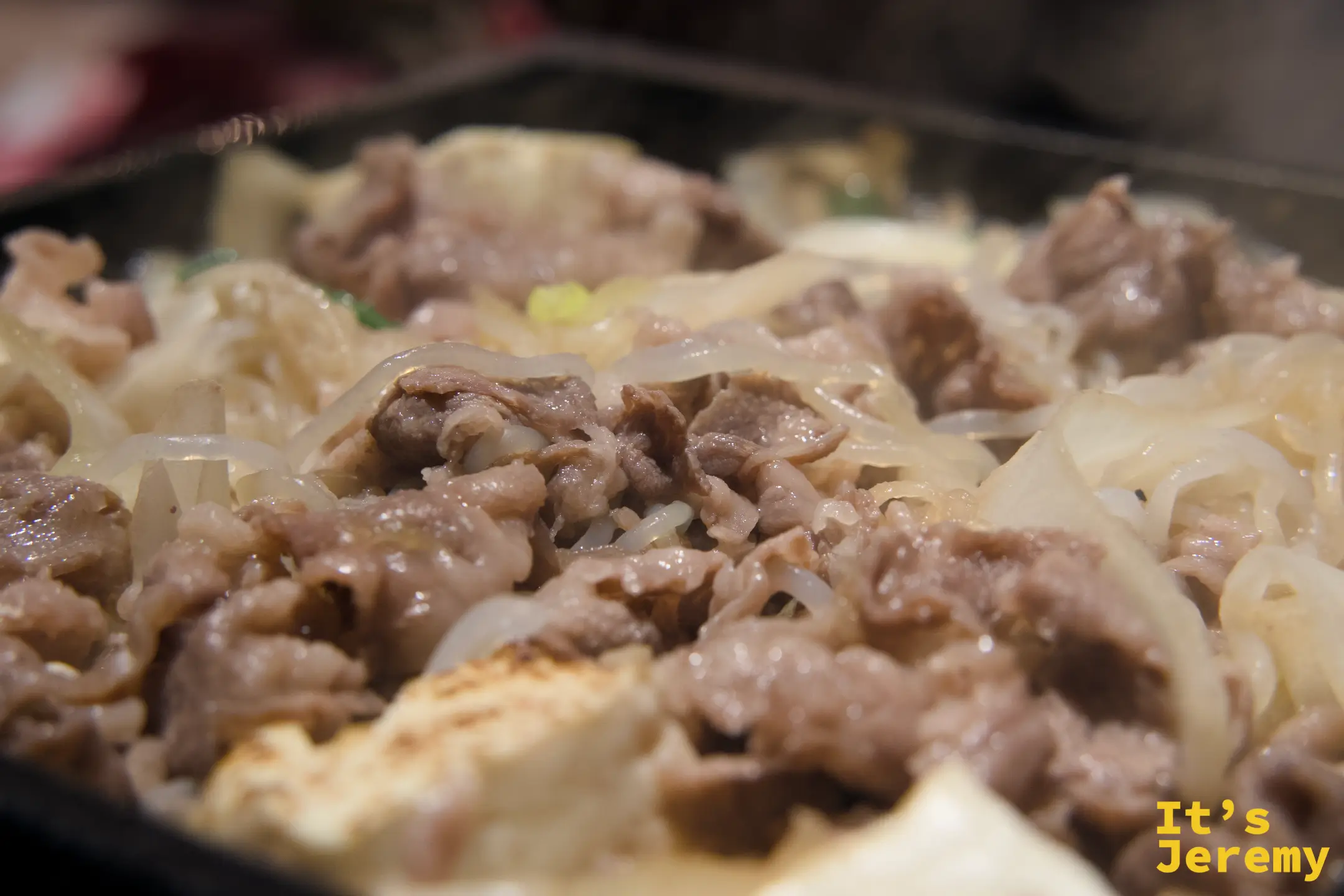 壽喜燒在鐵鍋中滋滋作響，牛肉與洋蔥同煮
